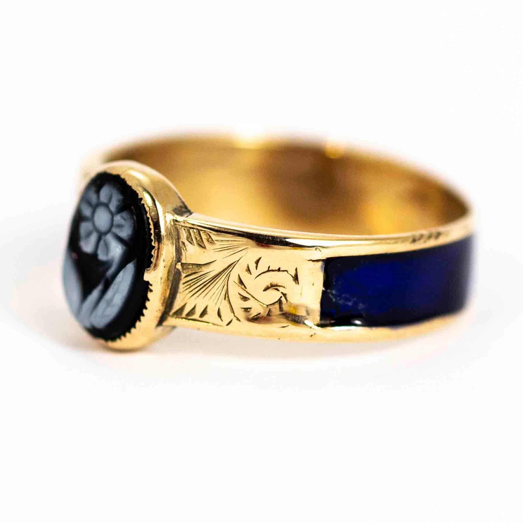 A beautiful antique ring from the Victorian period. Fronted with a oval sardonyx hand-carved into a wonderful forget me not flower. The shoulders are set with stunning hand-chased detailing and the rear of the band is set with royal blue enamel.