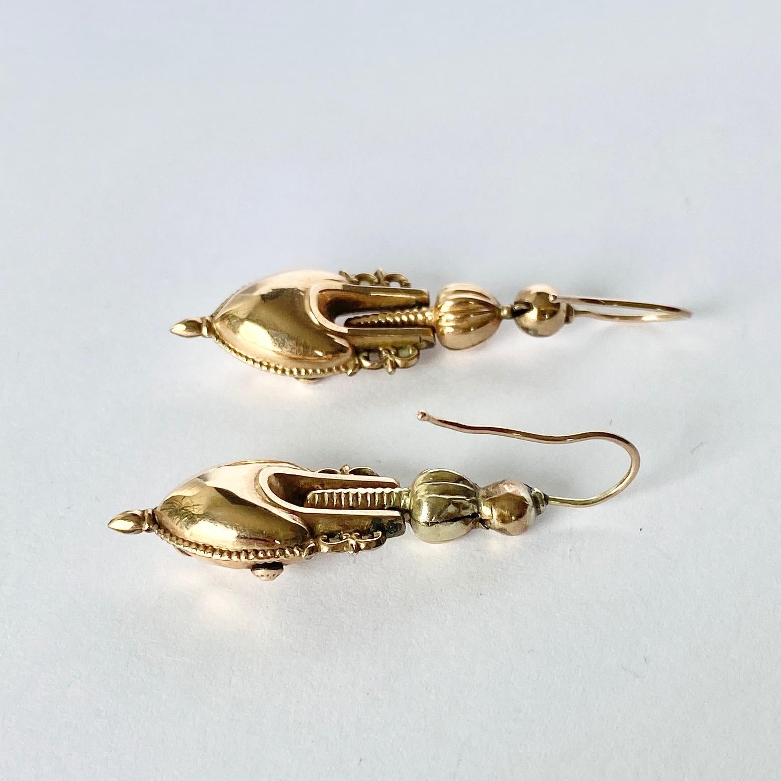 Diese atemberaubenden Ohrringe sind mit vielen komplizierten Details versehen und haben die Form einer Amphore. Sie sind in hervorragendem Zustand. Modelliert aus 9-karätigem Gold. 

Tropfen vom Ohr: 4cm 

Gewicht: 3,1 g