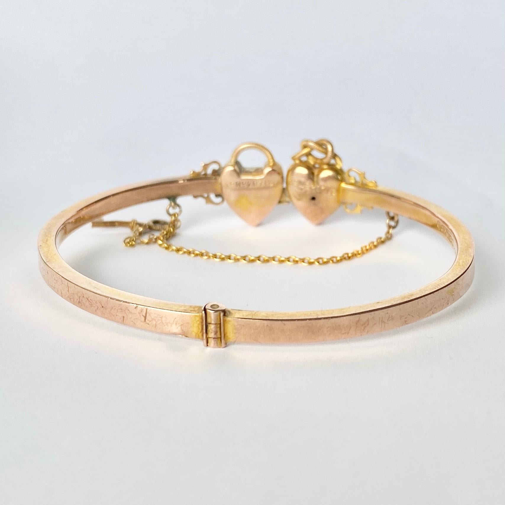 This gorgeous 9carat gold bangle has two hearts and a key. The gold is glossy and smooth and the fastening has a safety chain. The bangle opens by using the key. Fully hallmarked Birmingham 1892.

Inner diameter: 58mm 

Weight: 6.9g
