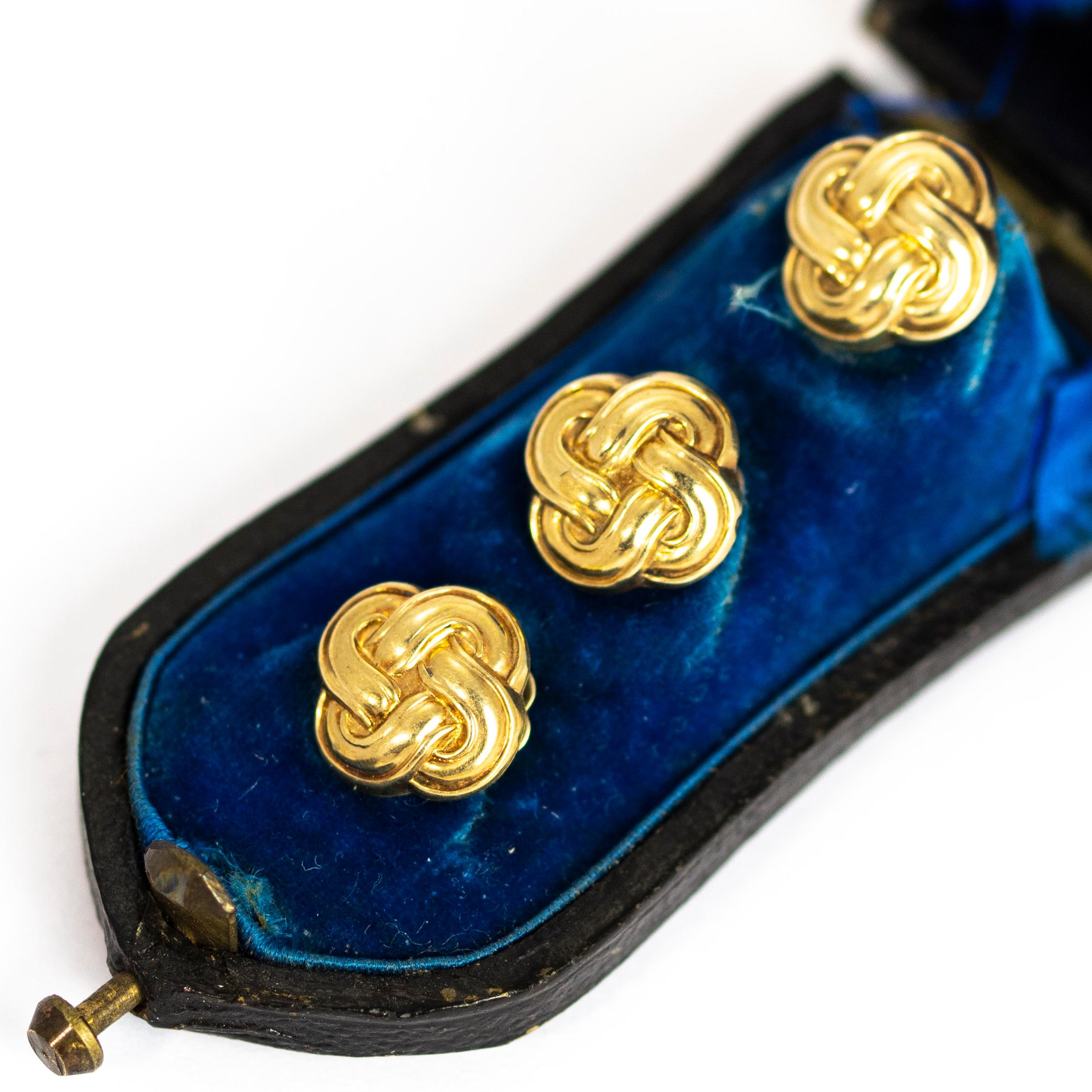 A wonderful trio of antique Victorian shirt studs elegantly formed into twisting lover's knots motifs. The backs are delicately hand chased with beautiful flowers and leaves, each with a different design. Modelled in 9 carat yellow gold. Set in