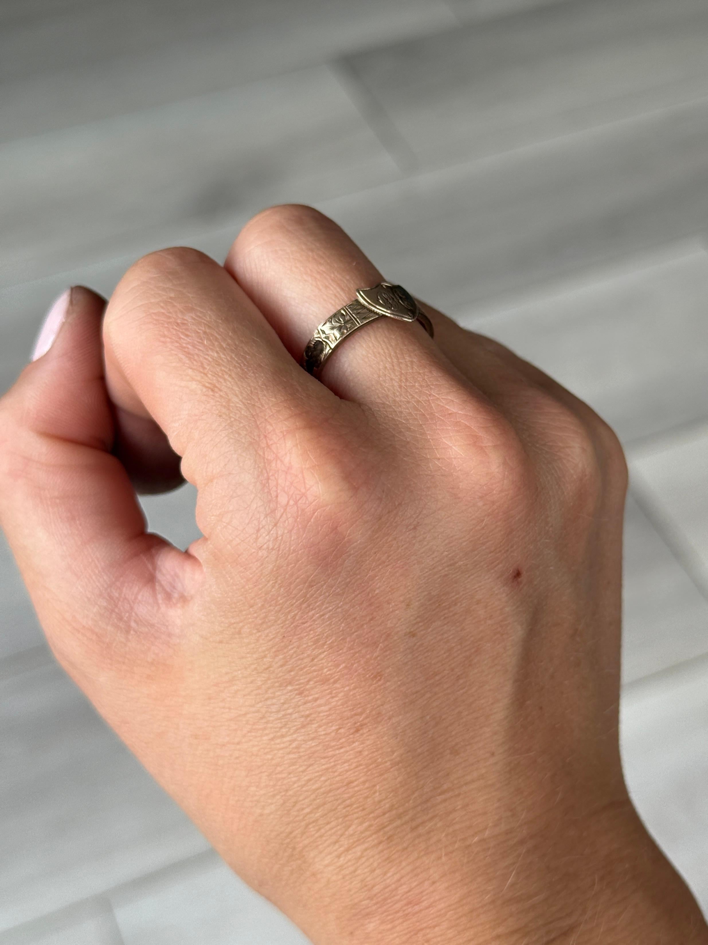 The shield at the front of this band has fancy initials finely engraved into it reading 'P.H.E'. The band itself is made up of panels with more gorgeous engraving all the way around and cut out panels revealing braided hair underneath. 

Ring Size: