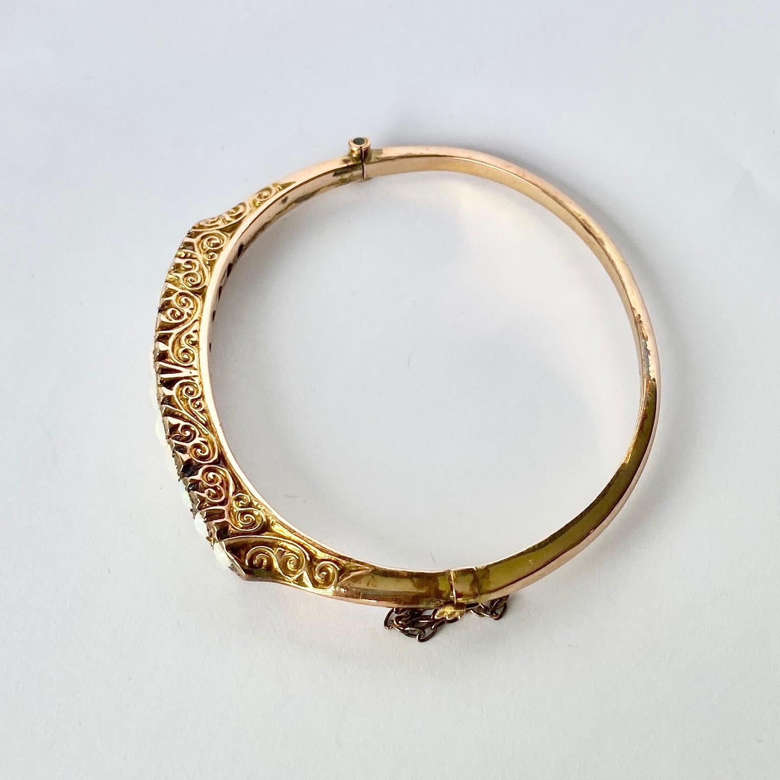 This bangle is modelled in 9carat gold and holds a total of 11 graduated opals. In between the bright and colourful opals there are rose cut diamond points. 

Inner Diameter: 57mm
Bangle Width: 8mm

Weight: 6.9g