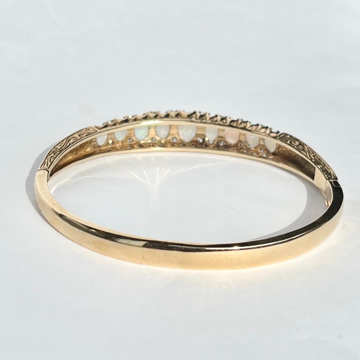 This bangle is modelled in 9carat gold and holds a total of 9 graduated opals. In between the bright and colourful opals there are sparkly diamond points. Fully hallmarked Sheffield 1991. 

Inner Diameter: 55mm
Bangle Width: 9mm

Weight: 18g