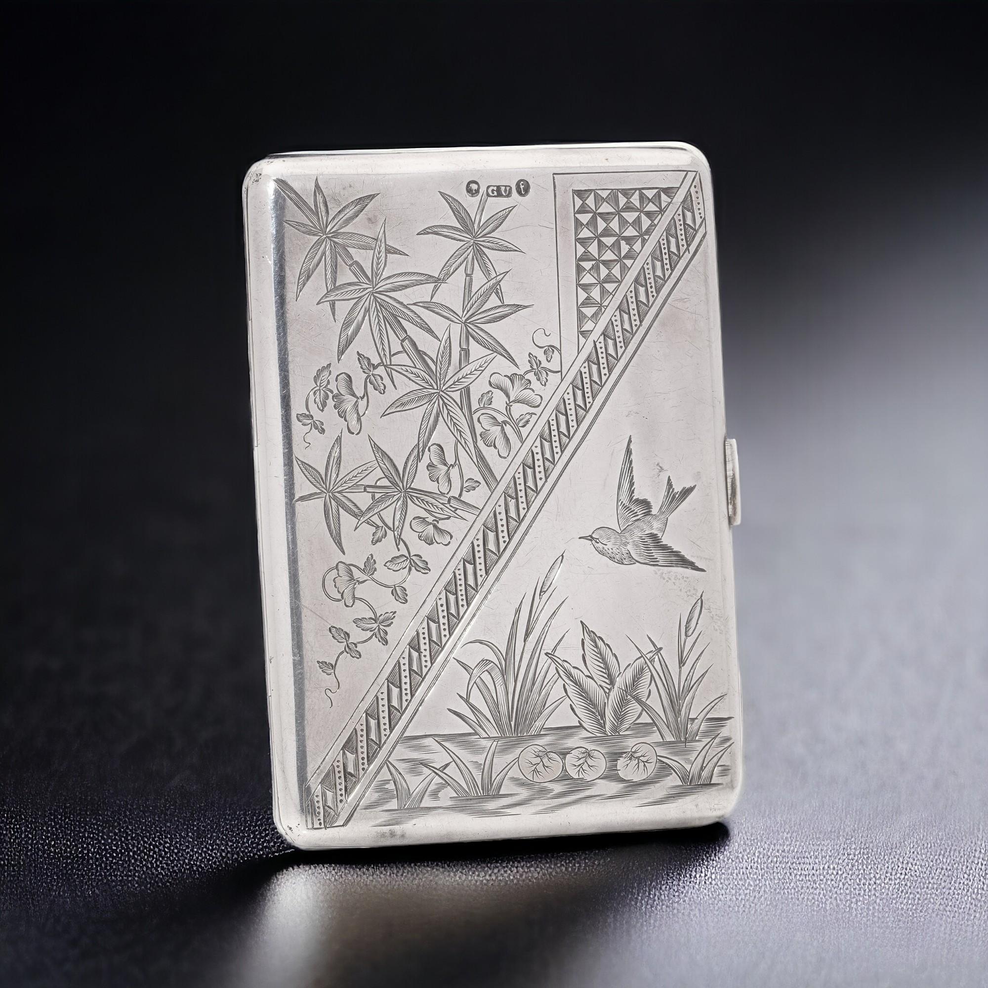 A beautifully embellished Victorian 925 sterling silver card case that intricately captures the enchanting influence of Japanese aesthetics prevalent during the Aesthetic Movement era. 

The obverse side showcases a dainty bird gracefully darting