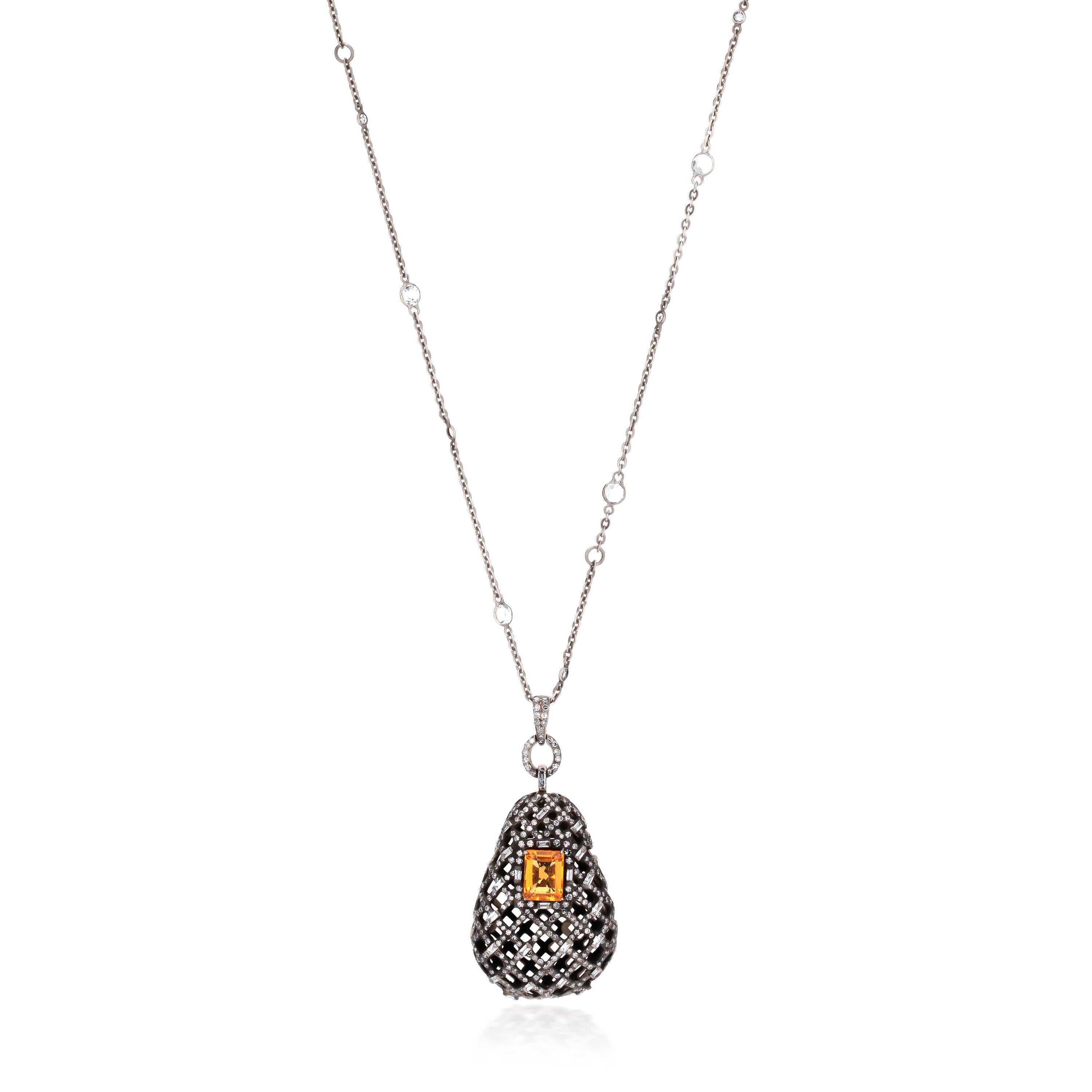 This dramatic antique dazzler showcases a pierced bell-shaped open space ornate pendant. The black bell-shaped pendant holds an emerald cut bold rectangular citrine at its center. The mesmerizing citrine sits amidst rows of baguette, pear, round,