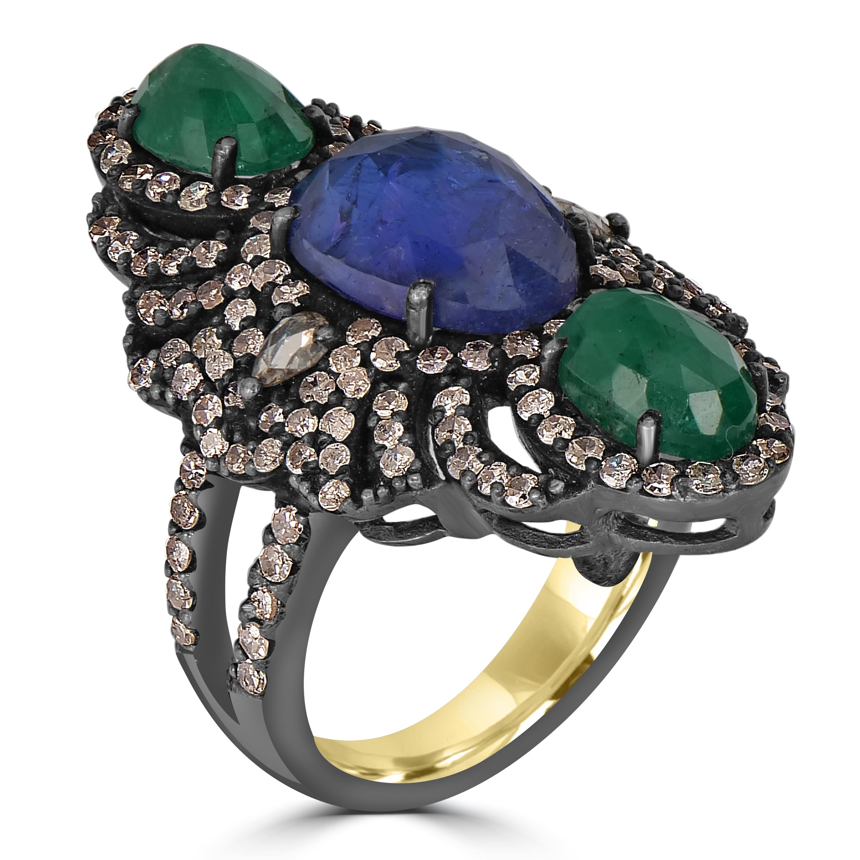 Introducing our opulent Victorian Tanzanite, Emerald, and Diamond Split Shank Floral Ring, a masterpiece that captures the essence of vintage elegance with a modern flair. Crafted with meticulous attention to detail, this ring features a captivating