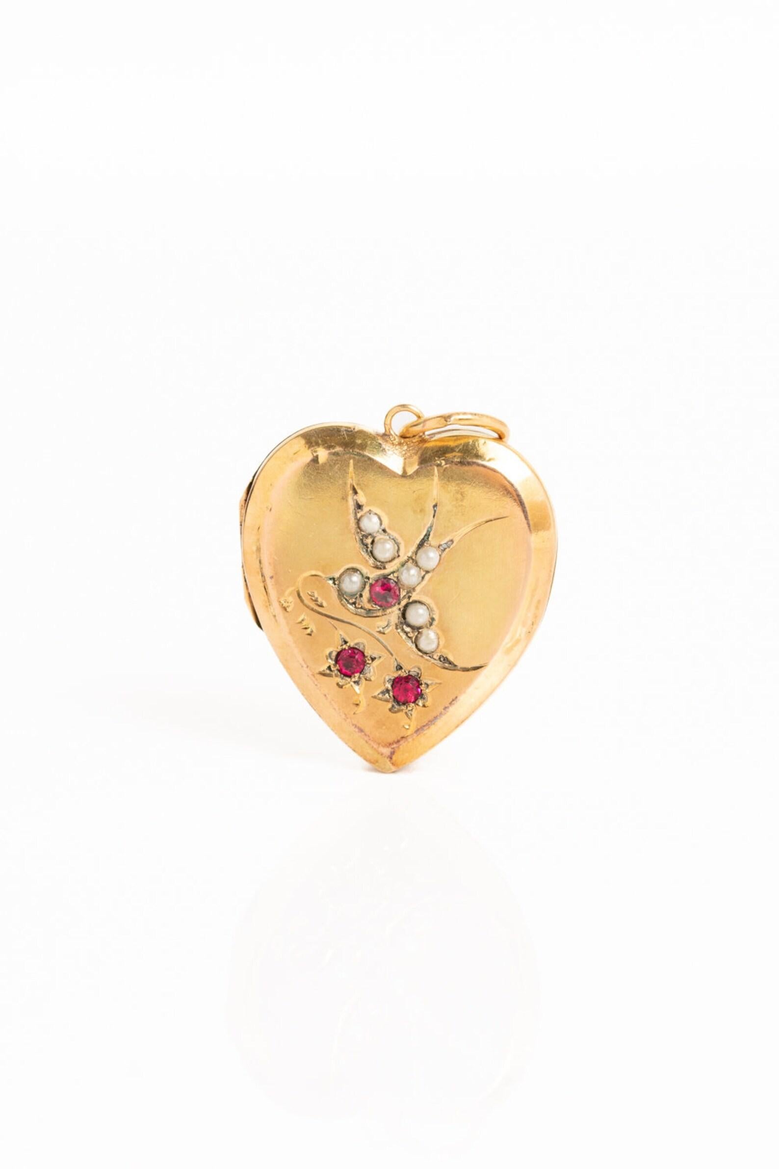 A wonderful Victorian 9ct gold back & front seed pearl and ruby heart locket with a swallow will make a lovely addition to your jewellery collection. The locket opens to reveal two compartments for photographs. The front of the locket is very
