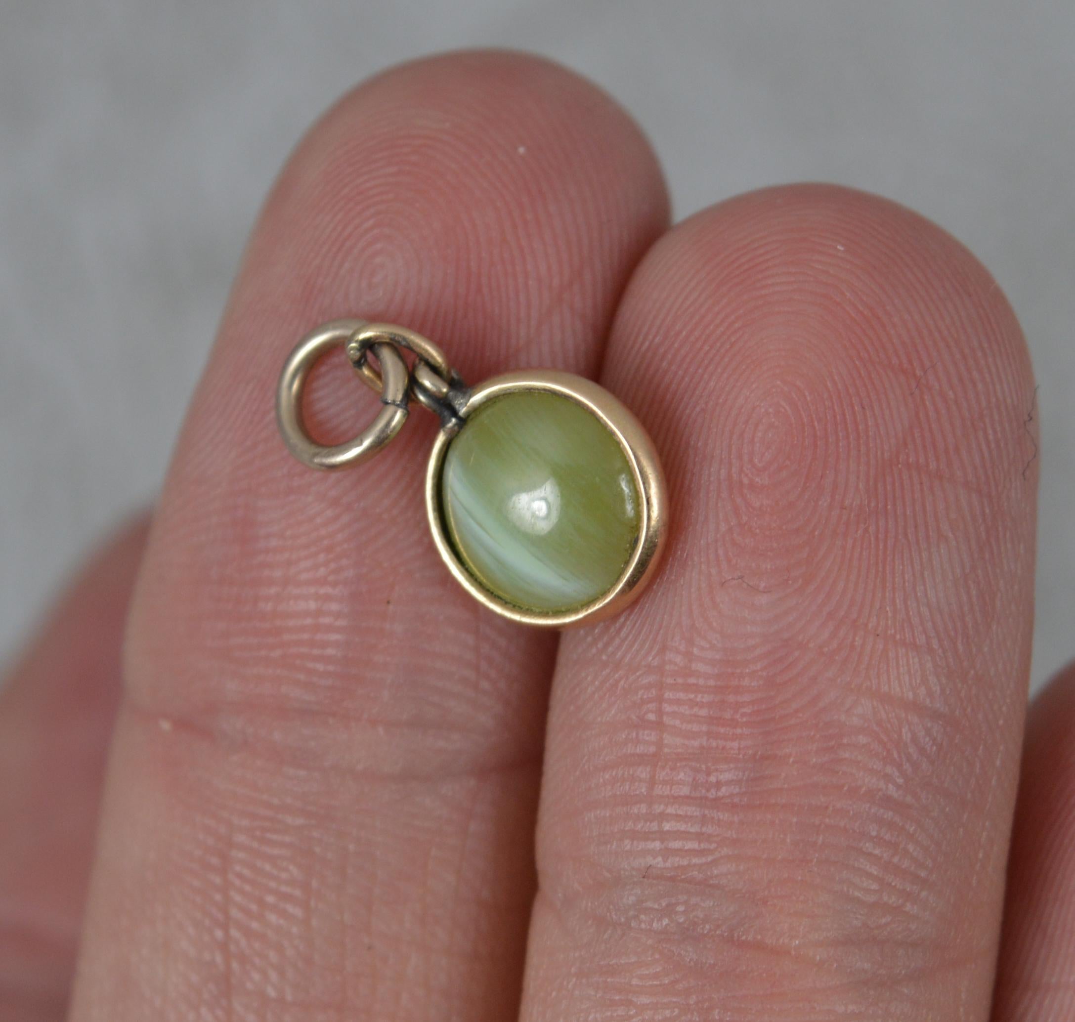 A Victorian era charm or pendant. Circa 1880.
Solid 9 carat rose gold bezel.
Set with a round cats eye chrysoberyl stone.

CONDITION ; Good for age. Clean design. Securely set stone. Light wear. Please view photographs.
WEIGHT ; 0.7 grams
SIZE ;