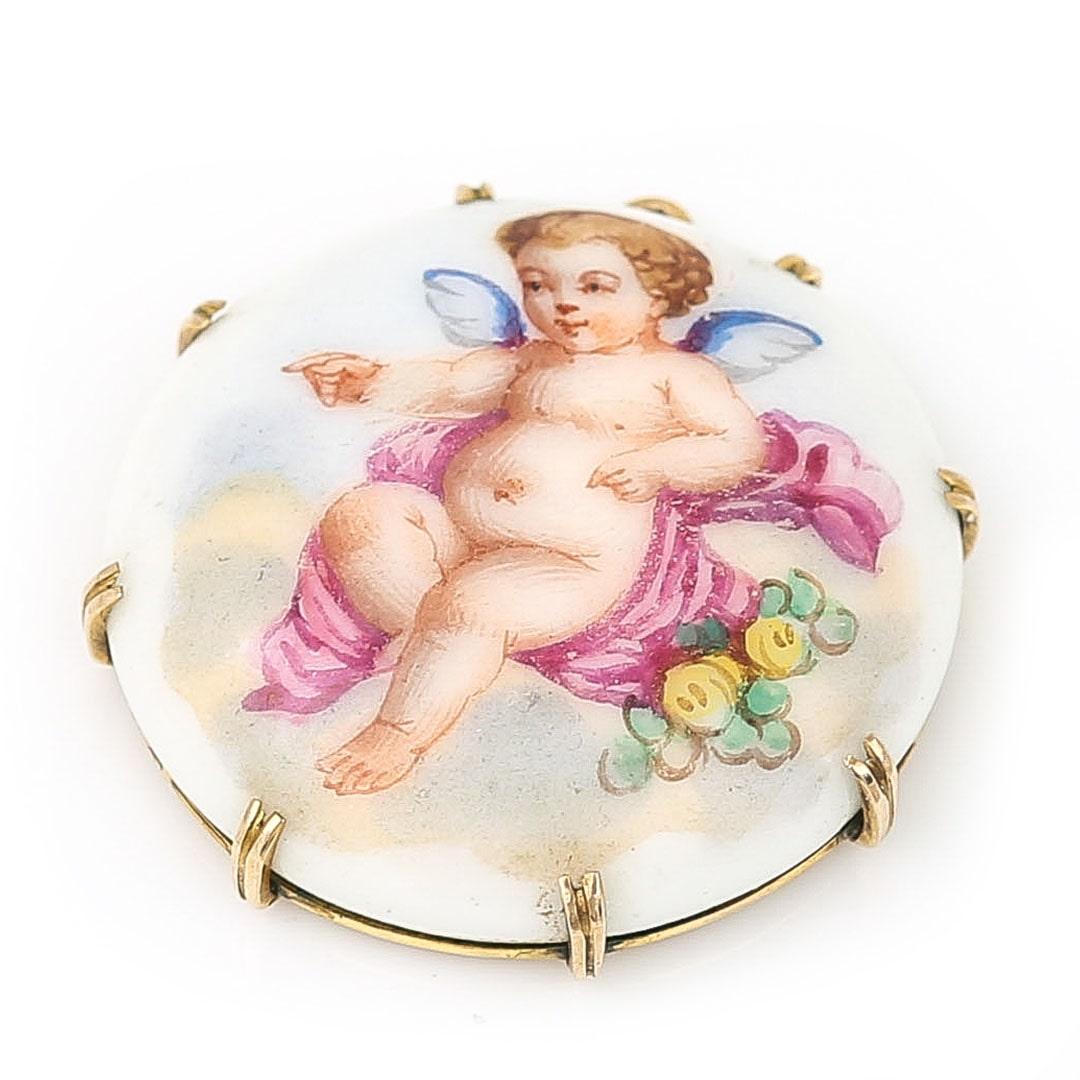 An adorably sweet Victorian pendant dating from the late 19th century depicting a cherub wrapped in a shawl adorned with flowers. The delicately hand painted scene retains it’s fine detail and the cherub possibly mimicking a similar gesture in
