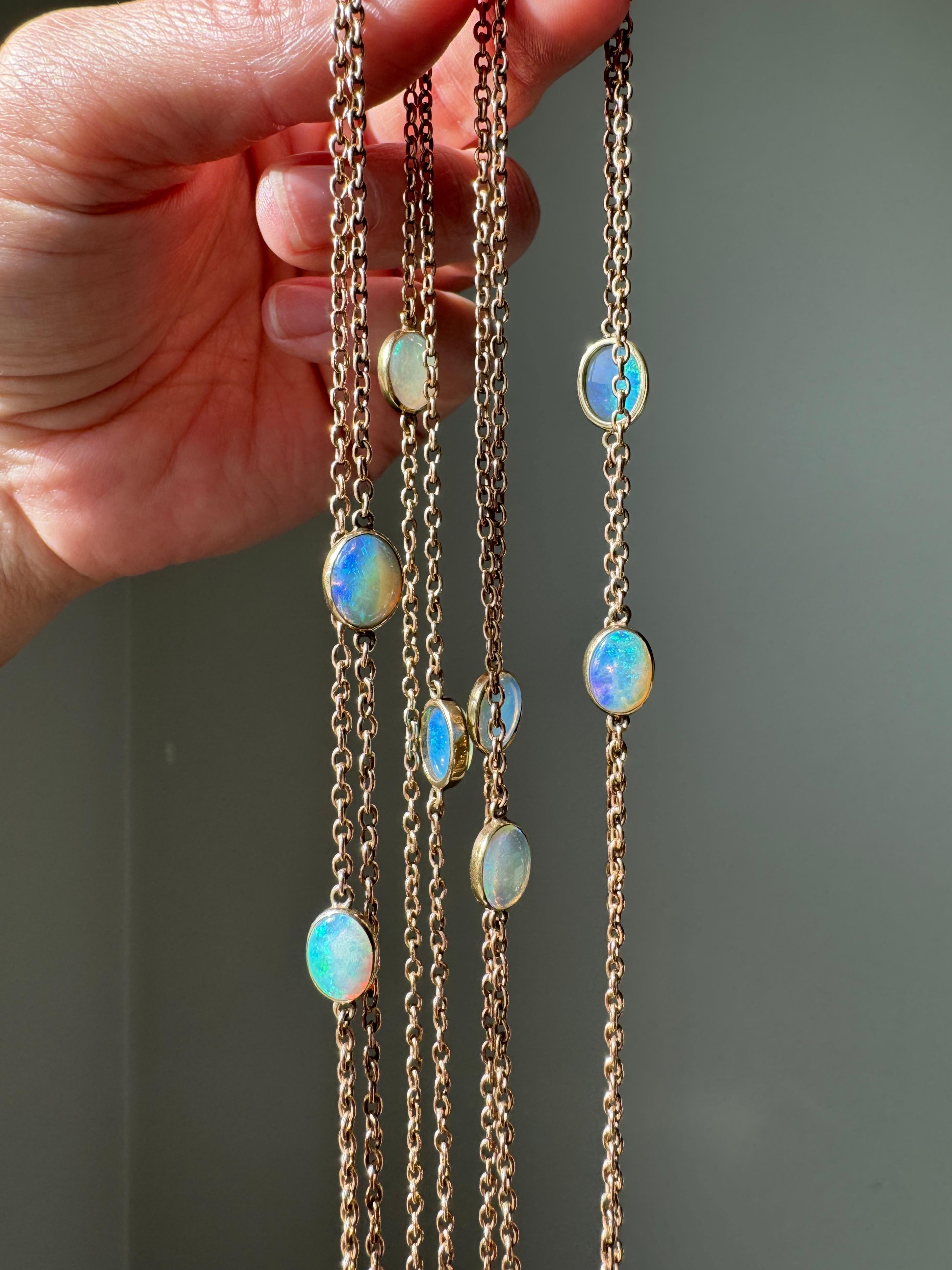 This wonderful seventy-none inch antique long chain is adorned with twelve cabochon opal stations suffused with glowing pastel blues and greens, calming violet contrasted by flashes of fiery orange on 9 karat rose gold cable link chain. This