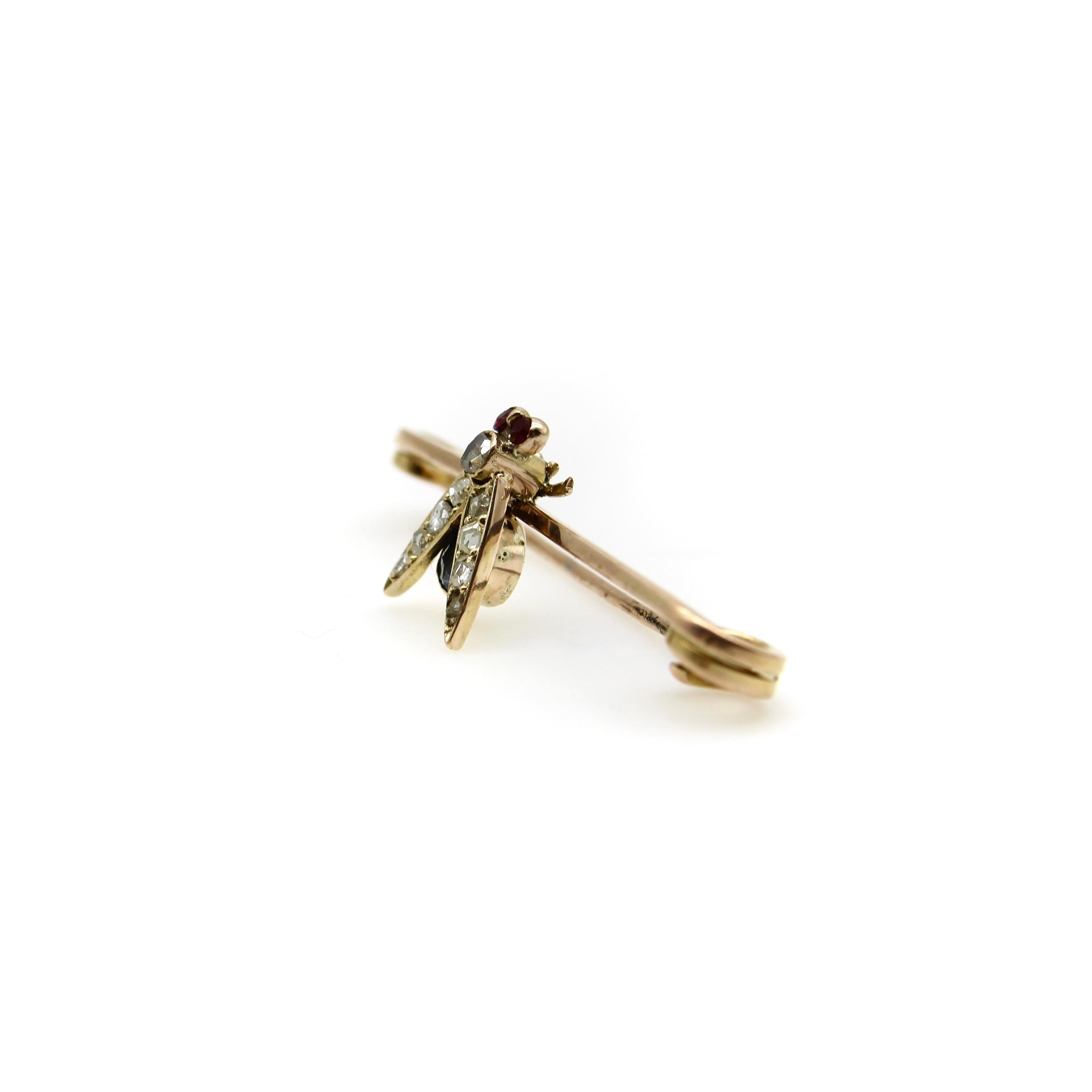 In der Mitte dieser Brosche aus 9-karätigem Gold sitzt eine wunderschöne, mit Edelsteinen besetzte viktorianische Fliege. Die Fliege hat rubinrote Augen, einen Rosenschliff-Diamanten als Brustkorb und acht Rosenschliff-Diamanten als Perlen in den