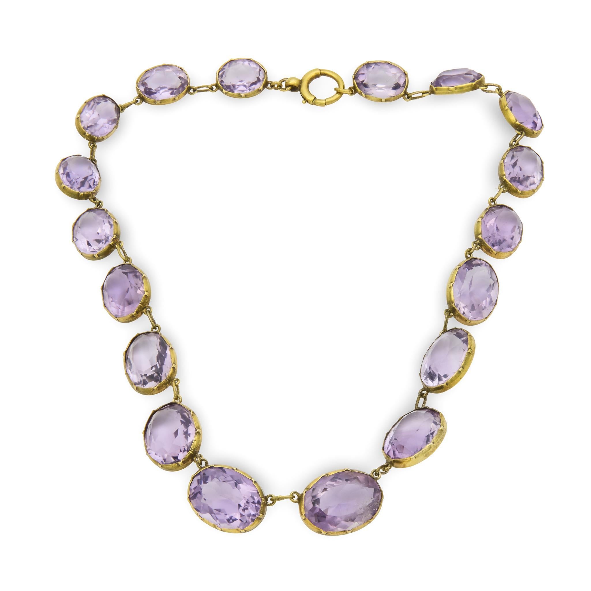 A dramatic and breathtaking amethyst riviera necklace from the Victorian (ca1880s) era! Crafted in 9k and sterling silver-gilt, this necklace is comprised of 18 oval-shaped faceted amethyst stones. Each amethyst stone displays a luscious purple hue,