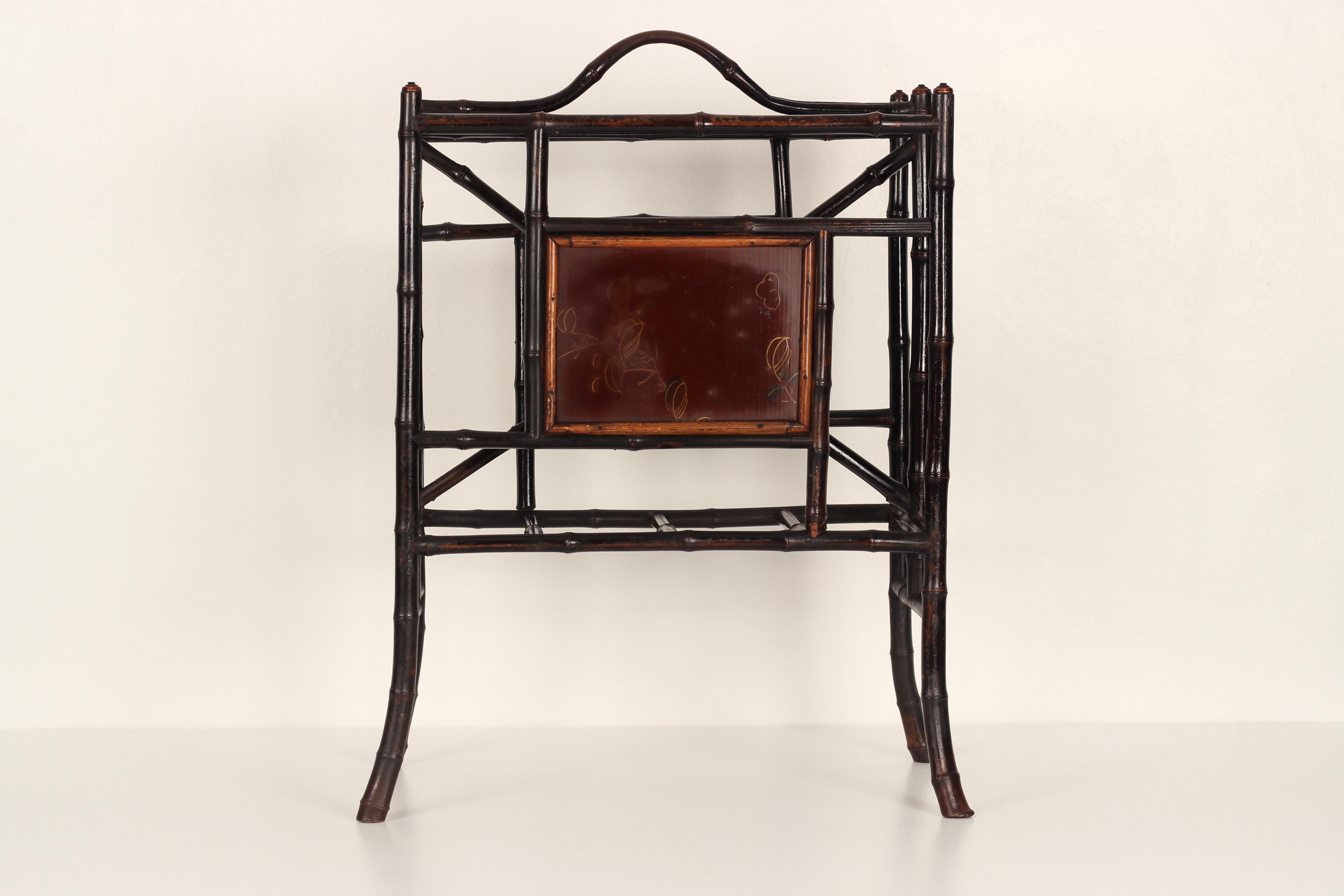 A Japanned Bamboo Victorian Aesthetic Movement Newspaper or magazine Rack/Canterbury with hand painted panels depicting stylised flowers and leaves.

The Aesthetic Movement was influenced heavily by the stylised renditions of China and Japan, and