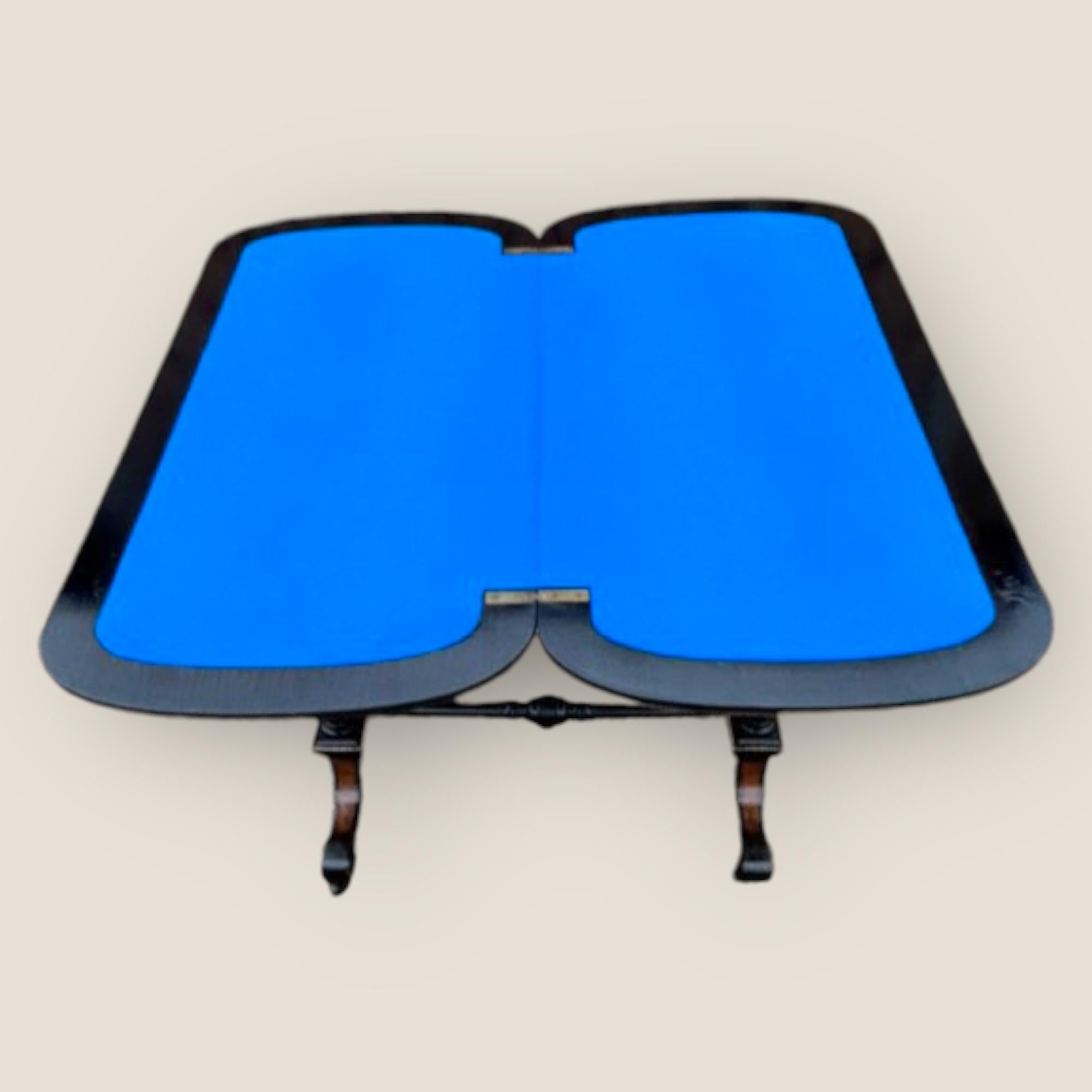 A very good quality Victorian Aesthetic Movement Card Table on casters. Burr Walnut and ebony, with a floral patterned embossed top. The top turns allow the table to unfold completely on the base. The card playing surface is a lovely blue velvet.