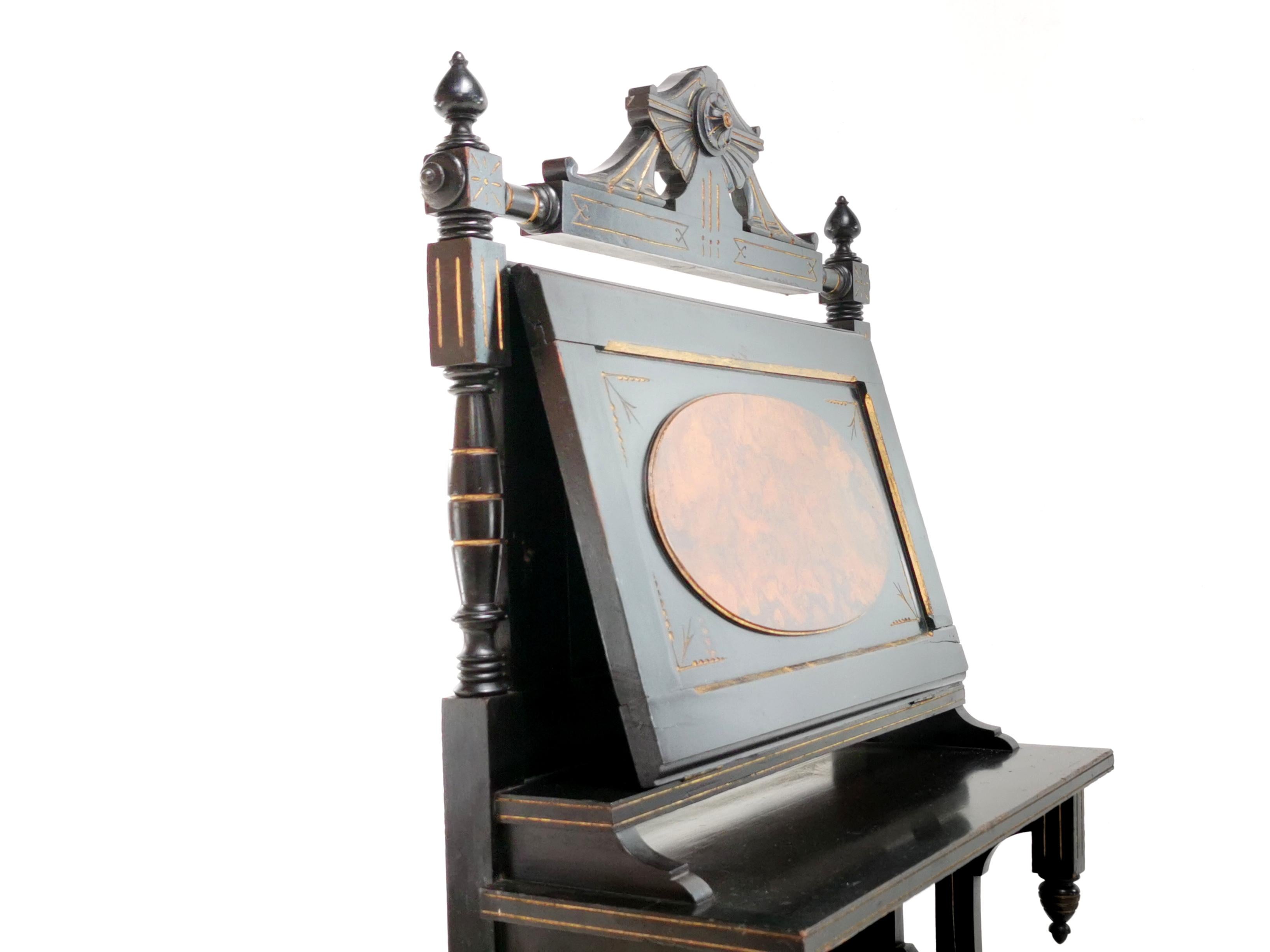 Victorian Canterbury

This rare, large scale Aesthetic Movement Canterbury sheet music stand has a fall front door for storing sheet music, ebonised wood with gold detailing and lower dividers. It is an excellent example of original late Victorian