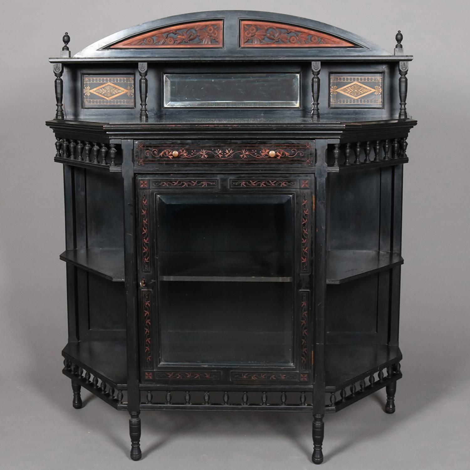 Victorian aesthetic movement Kimbel and Cabus School server features black lacquered case with bevelled mirrored gilt decorated backsplash with display shelf and carved floral demilune crest, single glass door cabinet also with gilt decoration and