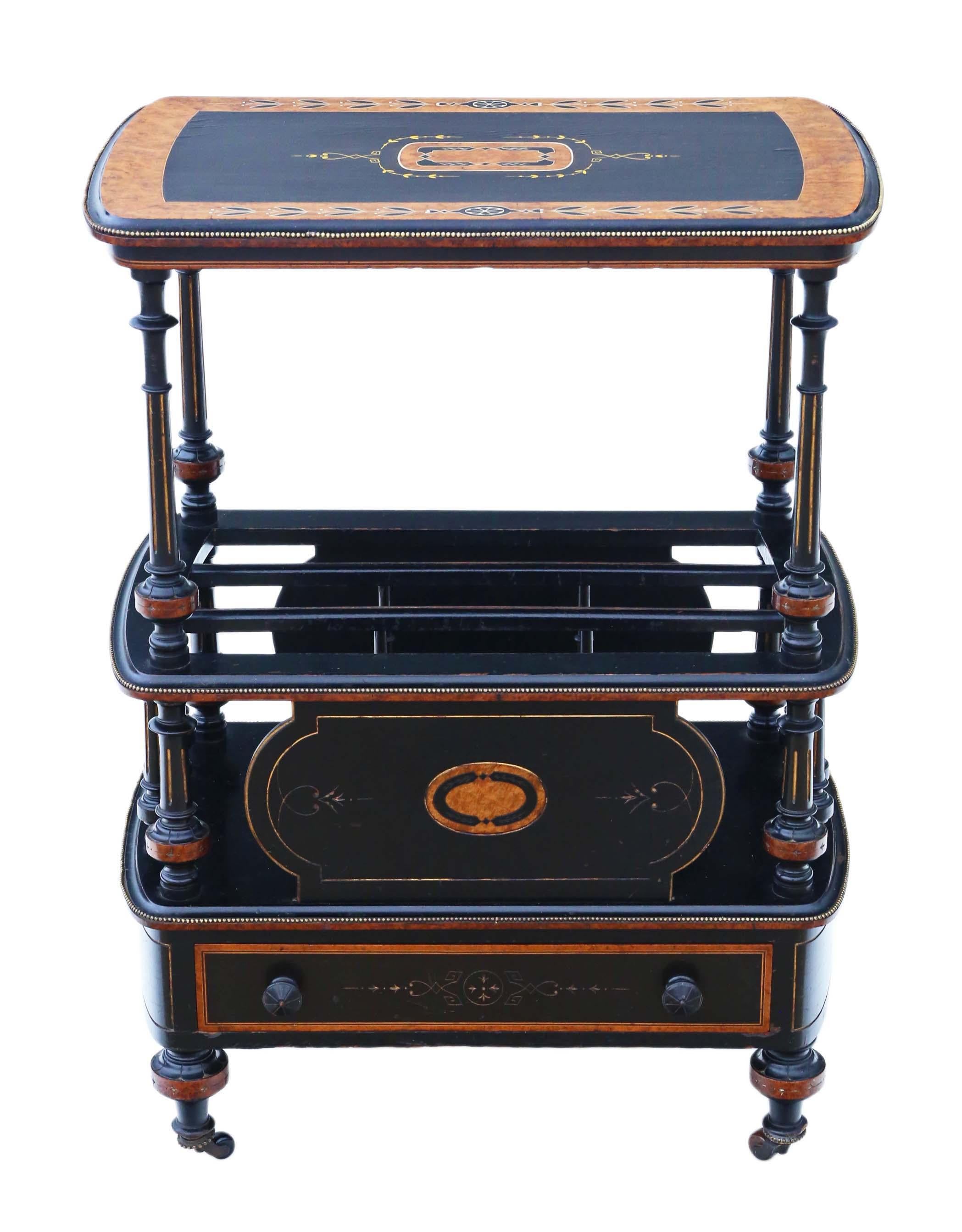 Antique Victorian Aesthetic Canterbury whatnot dating from around 1880, elegantly ebonized with inlaid amboyna and brass edging, presenting a delightful mix of charm and character.

This is a rare and attractive quality piece, featuring a decorative