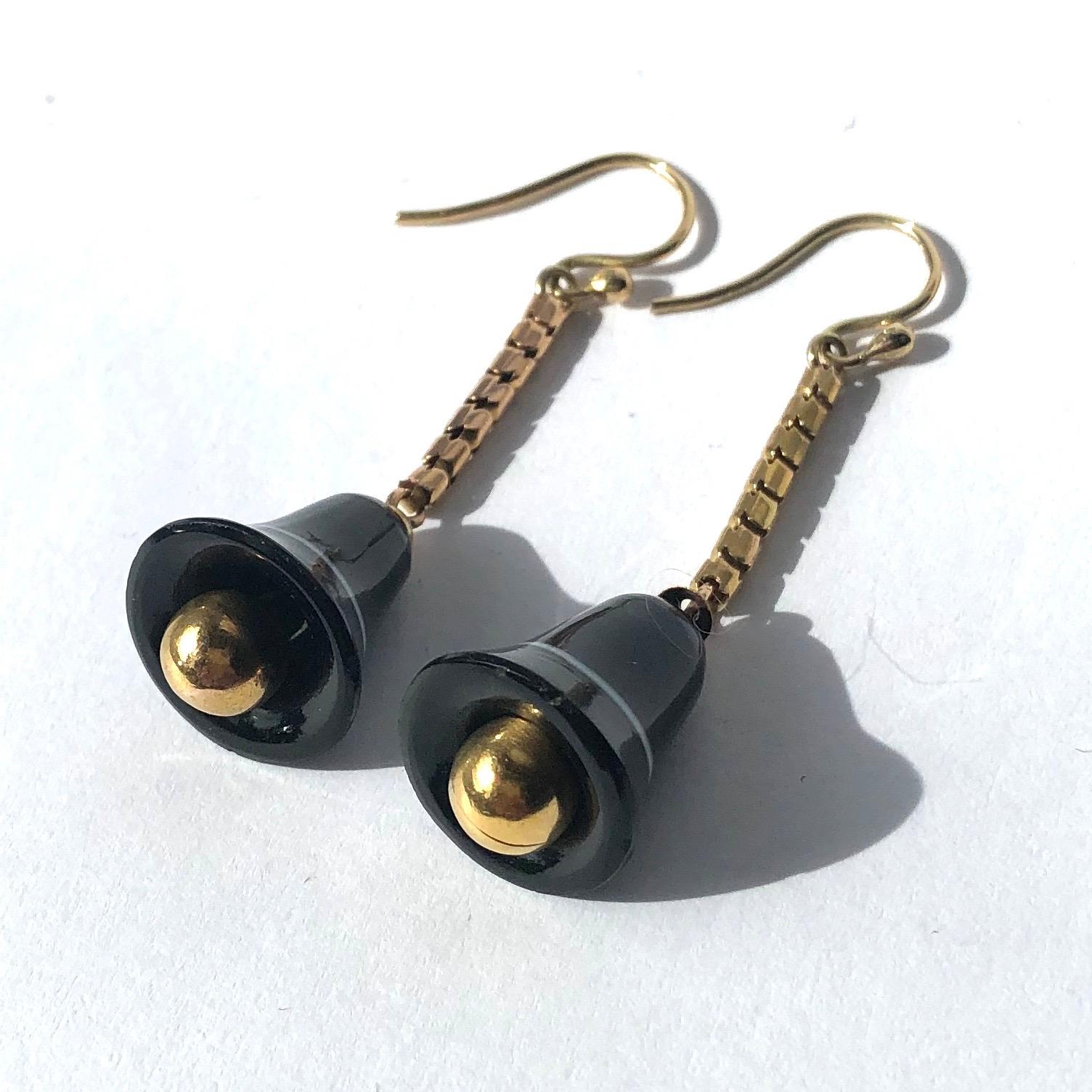 The bell style shape of the drop earrings work so well with the banded agate. The white band which runs around the glossy black bell works brilliantly. Connecting the agate to the shepherds hook is a snake chain. 

Drop From Ear: 43mm

Weight: 6g