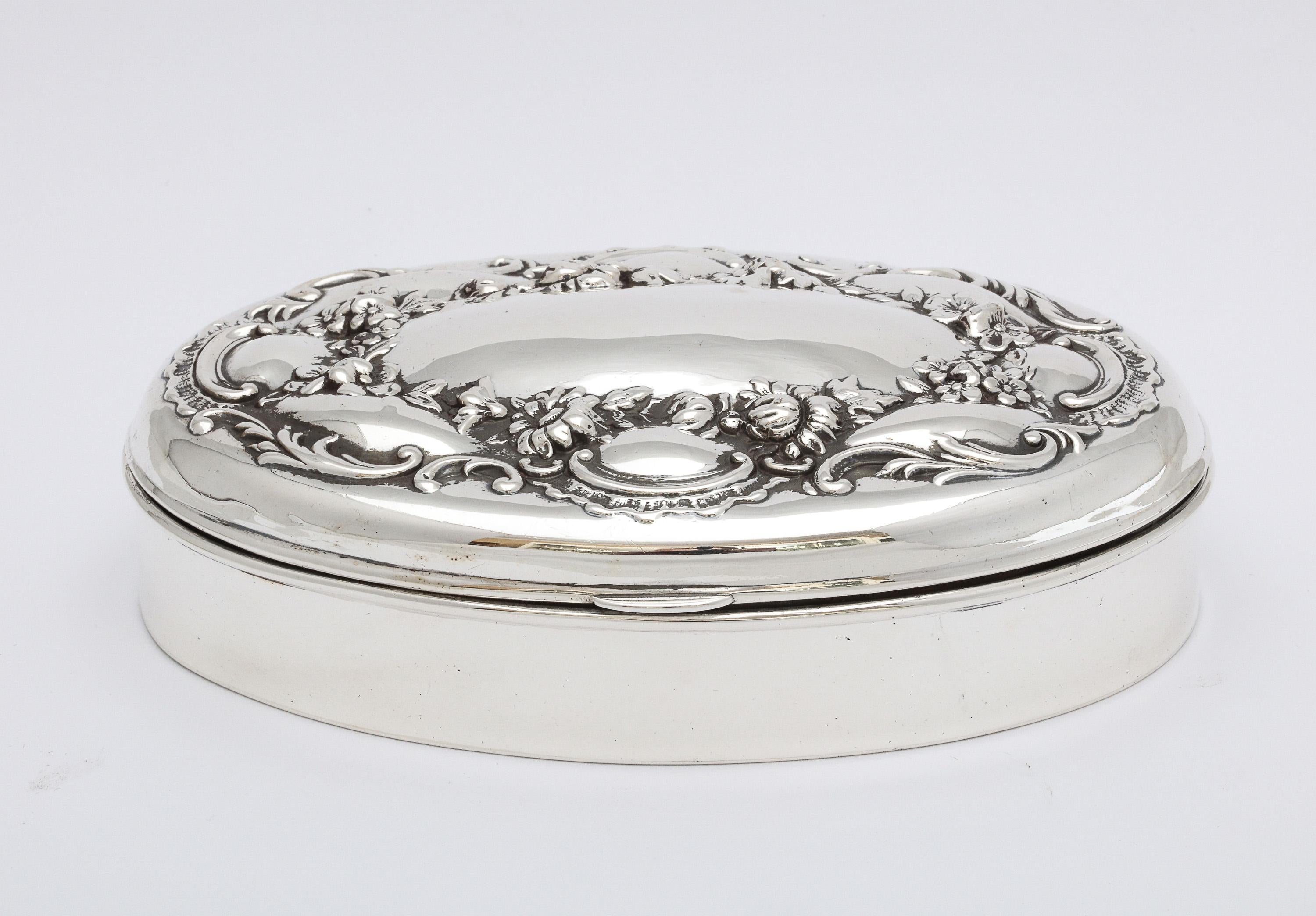 Victorian, all sterling silver trinkets box with hinged lid, Redlich and Company,, circa 1895. Lid is decorated with a lovely floral design; underside of lid is gilded. Bottom of inside of box is lined with red leather. Measures 5 inches wide x 3