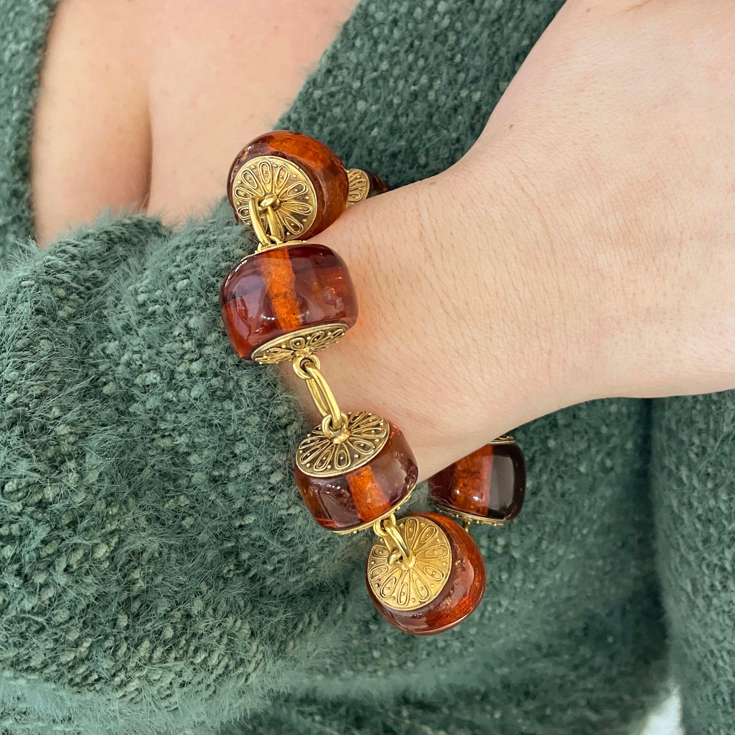 An antique amber and gold bracelet, with large amber beads, with gold discs either side, decorated with Etruscan style wirework, with single oval gold links, in a Richard A. Green fitted case, with gold M. A. S. initials, in gothic script, circa