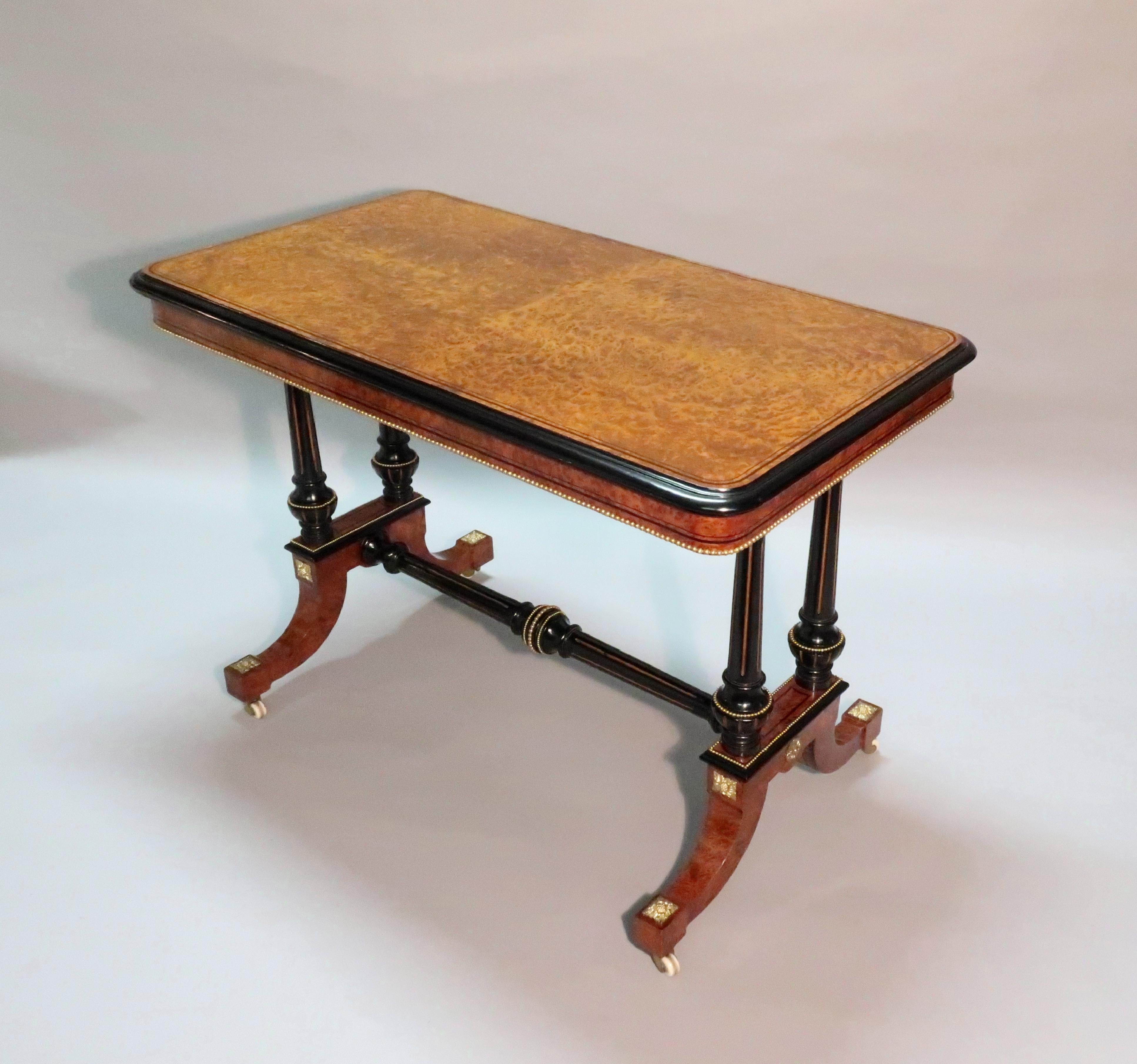 An exceptional quality and rare Victorian amboyna wood and ebonised occasional or side table with ebony string inlay to the top and frieze. The table has gilt fluted columns and stretcher with beaded ormolu mouldings and mounts.
 
The table is