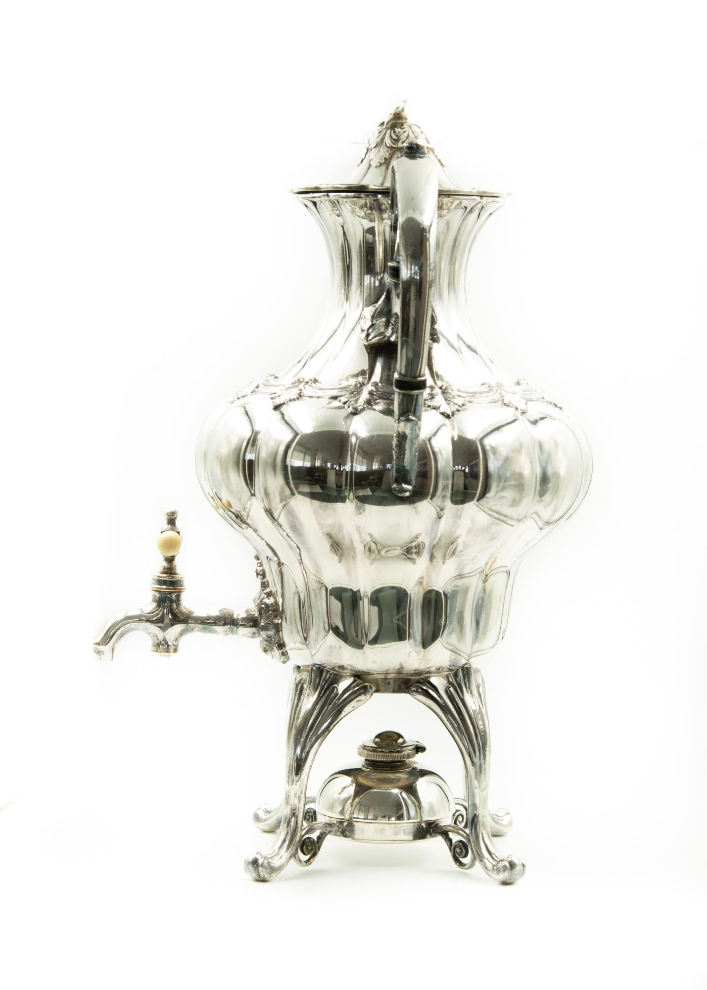 This late 19th century silver plate coffee urn is ornately designed with its flower finial, removable heating element and bone handle to protect your fingers from the heat. Probably late Victorian, it is charming on any buffet whether serving coffee