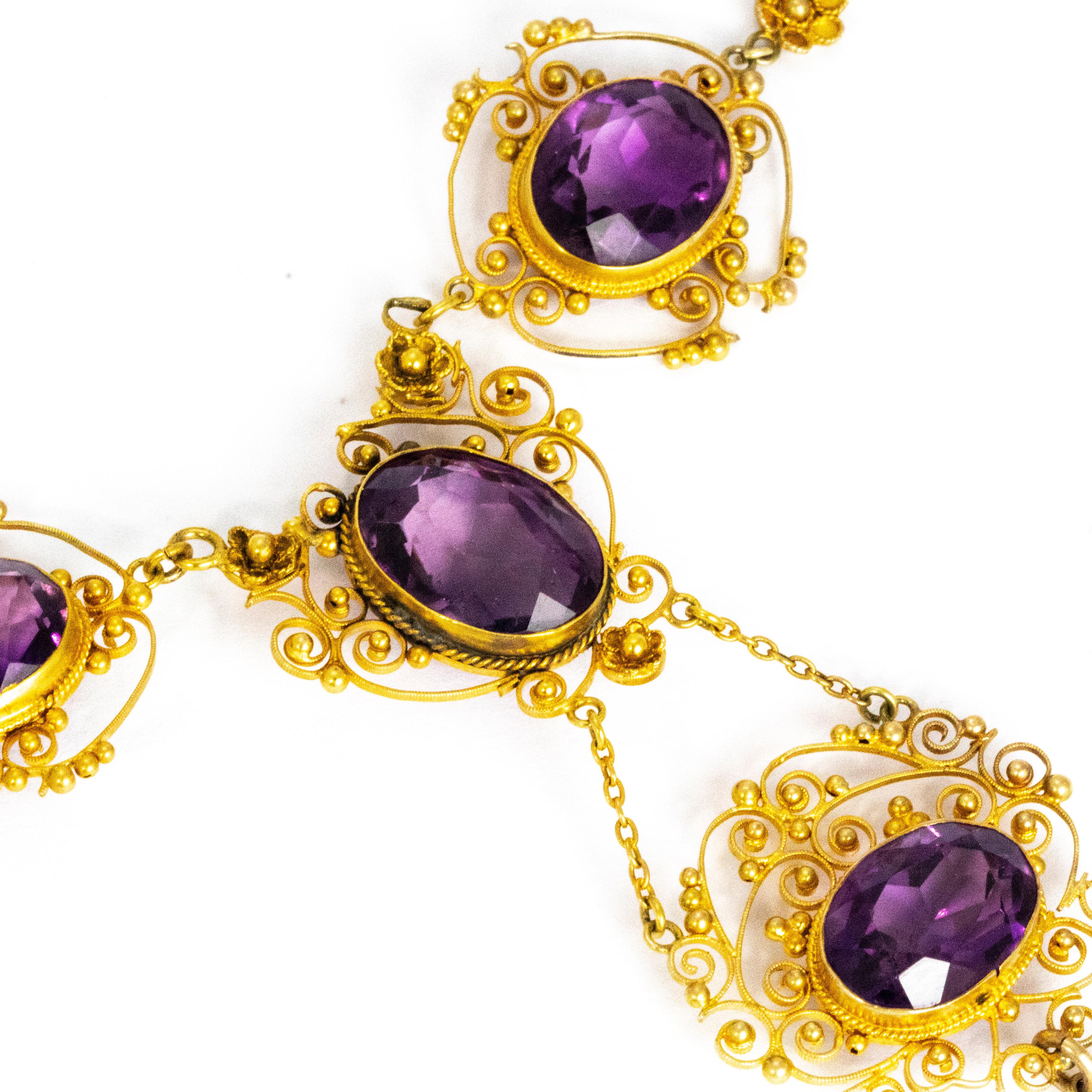 This fabulous filagree work necklace holds five good sized amethysts, four are oval and one of which is a tear drop shape. This piece is exquisite, each setting has delicate scroll, beaded and tiny flower details all modelled in 15ct gold. All the