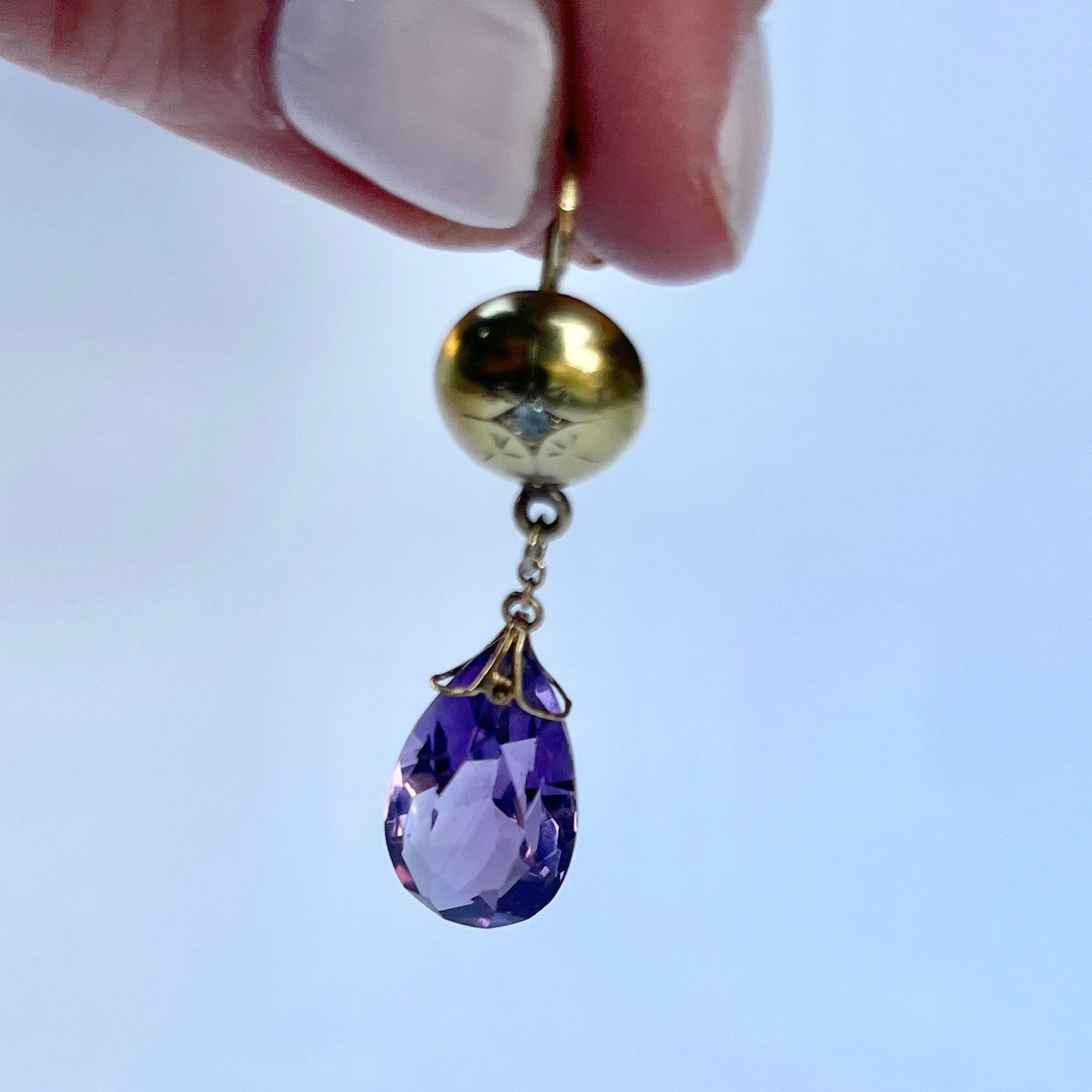 The stunning amethyst stones are delicately attached to the main earring with fine gold wire. The discs each hold a single diamond set in a star setting. Modelled in 9 carat yellow gold.

Total drop from ear: 4cm

Weight: 3.9g