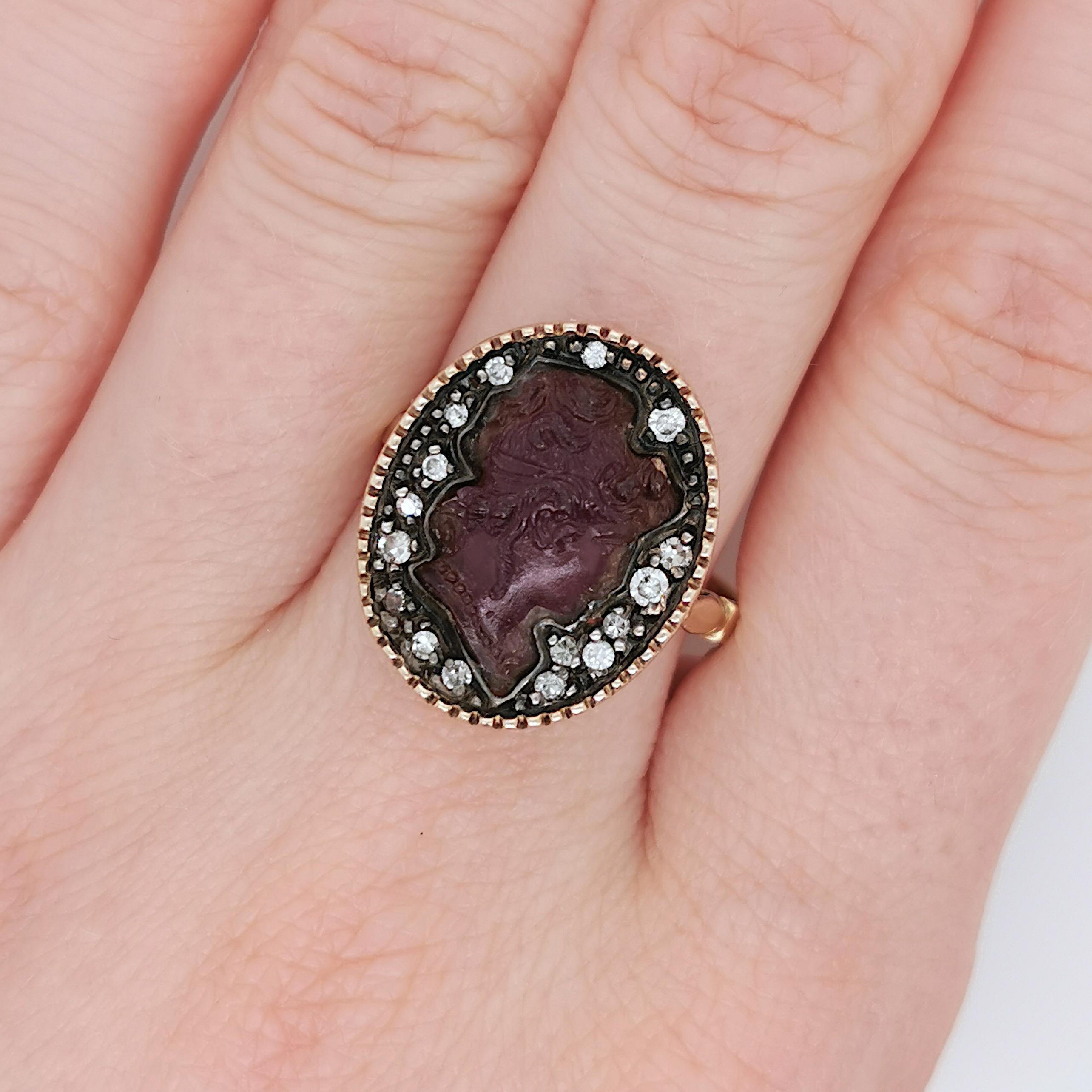 An amethyst cameo ring, comprised of an oval carved amethyst of a woman's head in profile, surrounded by eight-cut and round brilliant-cut diamonds, mounted in gold with a silver setting, with a maker's mark outside the shank. Circa 1880.

Finger