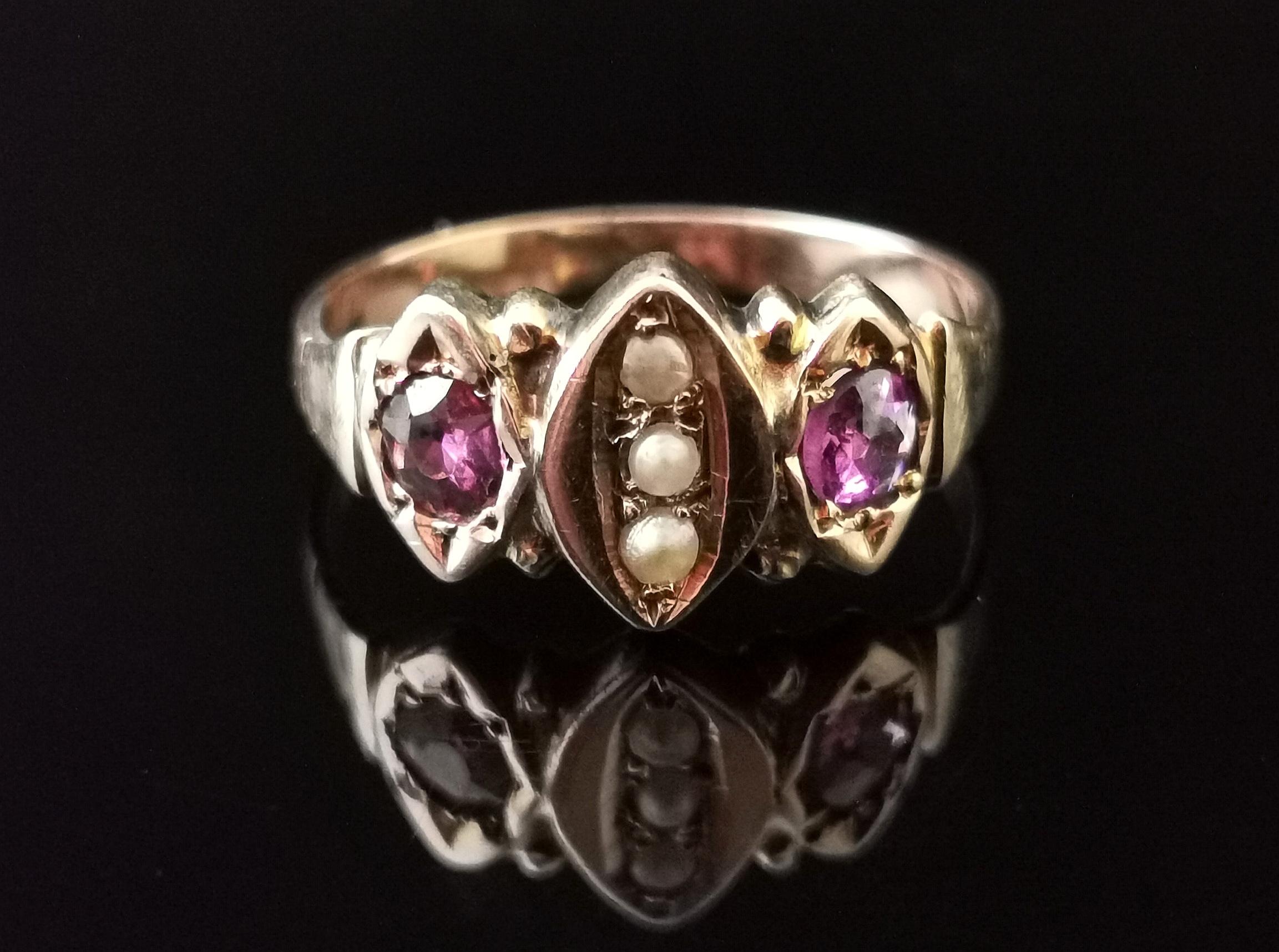 A pretty antique Victorian Amethyst and seed pearl ring in 9kt Rose gold.

This ring has a navette shaped centre set with three creamy seed pearls which is shouldered each side by a rich purple round cut Amethyst.

It has a 9kt gold band and the
