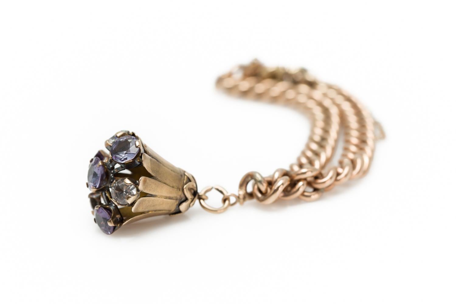 An antique Victorian Amethyst and white Quartz floral-shaped single charm bracelet in 14K rose gold from the late 19th century. Crafted in the USA, this antique Victorian bracelet features Amethysts of approximately 7mm, alternating with 5.85mm