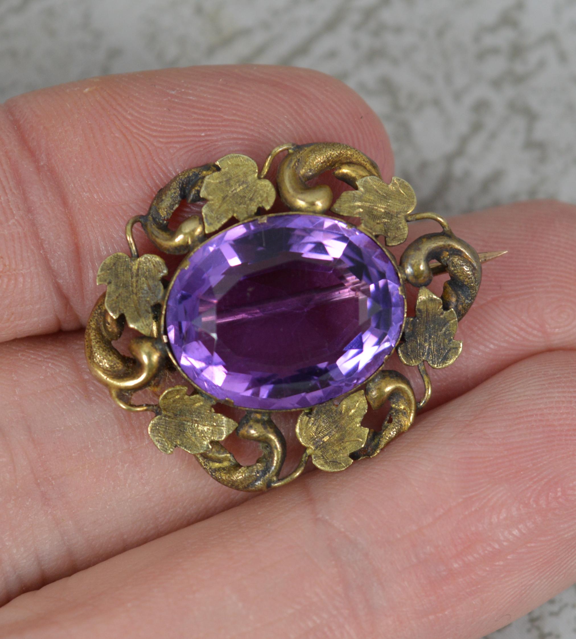 A mid Victorian period brooch.
Solid 9 carat gold example. A fine floral shape.
Set with an oval cut amethyst to centre, 12mm x 15mm. 

CONDITION ; Good for age. Well set, clean amethyst. Clean gold, some general wear. Uncleaned. Please view