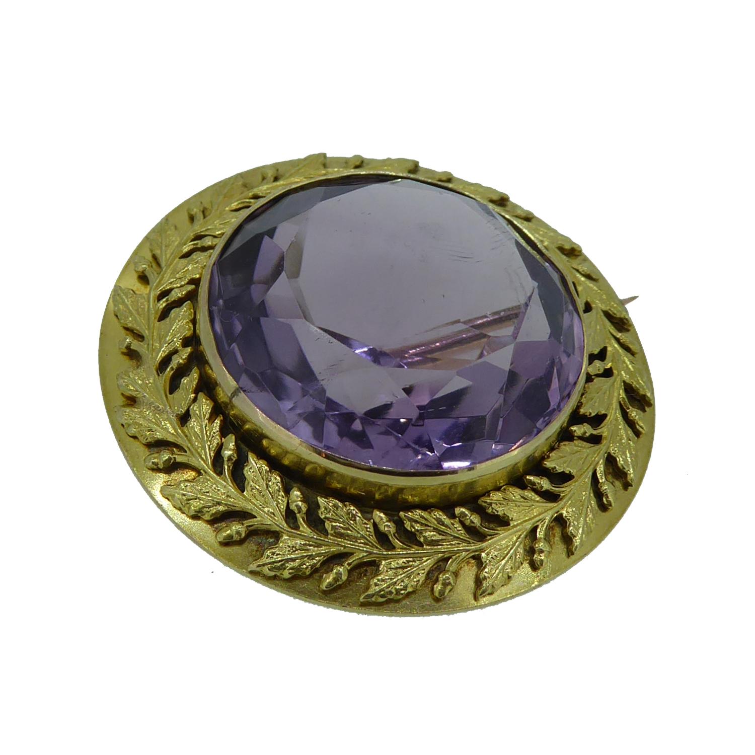 This antique brooch is set with a round faceted amethyst in a gold collar setting and measuring approx. 0.75