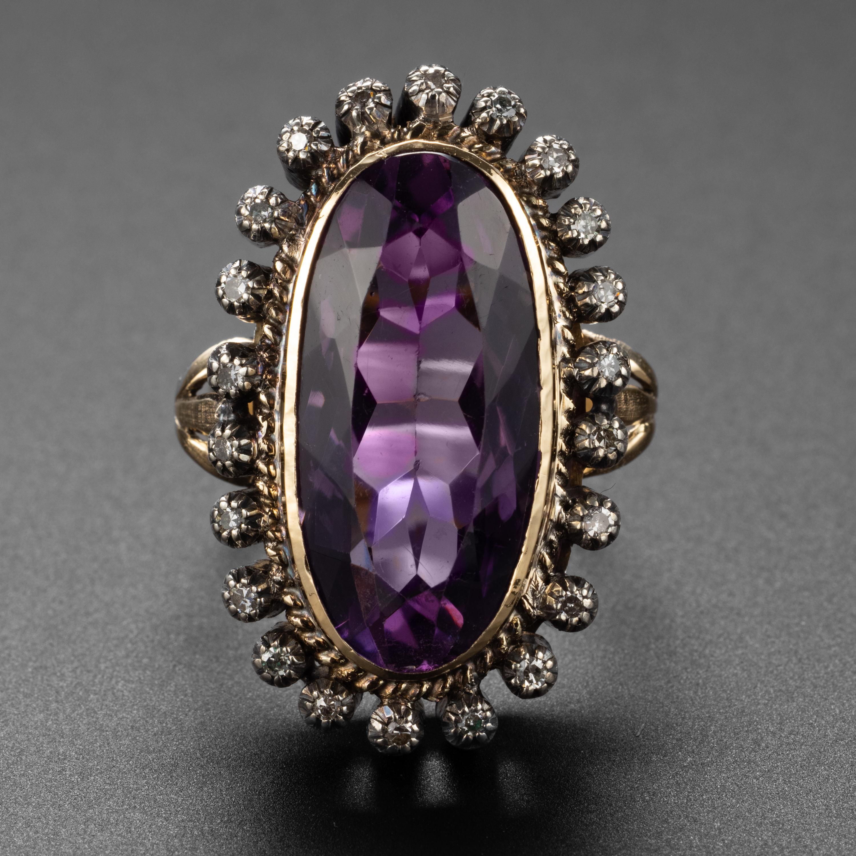 This circa 1890s ring features an impressive oblong oval-shaped 11 carat amethyst with excellent purple and rose coloring. The 23.63mm x 11.33mm is surrounded by a halo of 22 tiny European-cut diamonds, each set into its own silver collet. Together