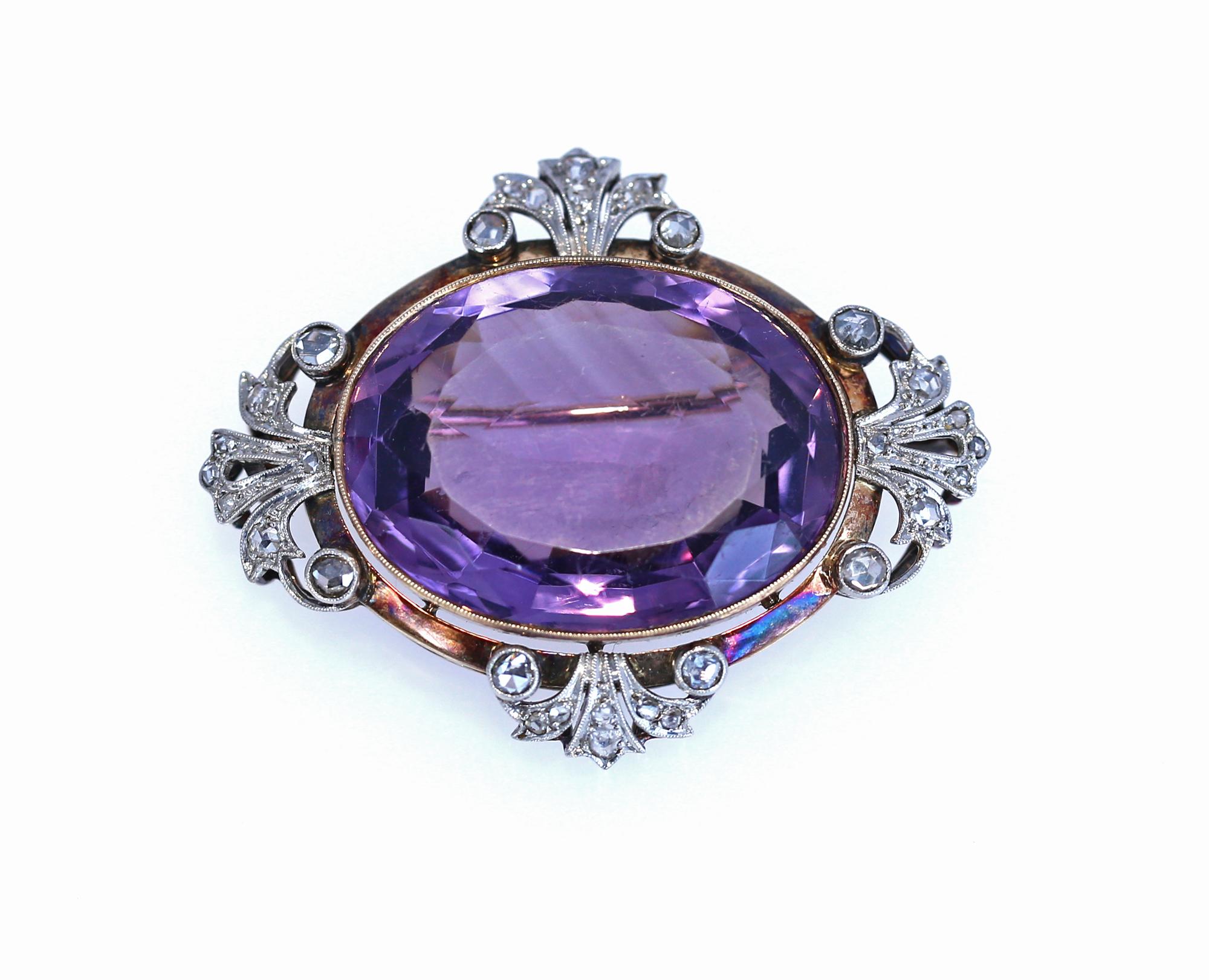 Late Victorian big and bright Amethyst silver set and 18 carat gold mounted brooch with an exceptionally brightly coloured amethyst in the  centre. The stone is surrounded of single rose cut diamonds and is multifaceted to the reverse to give the