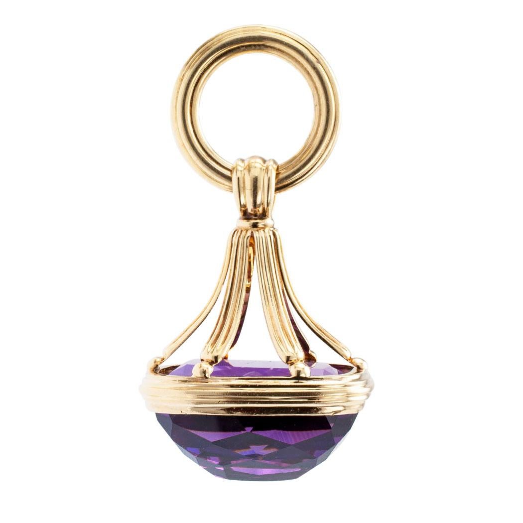 Victorian amethyst and gold fob circa 1890. The open design showcases a bezel-set, rectangular, faceted amethyst suspended from a large ring. The amethyst’s underside, the pavilion, exposed to light from all directions, mounted in 14-karat yellow