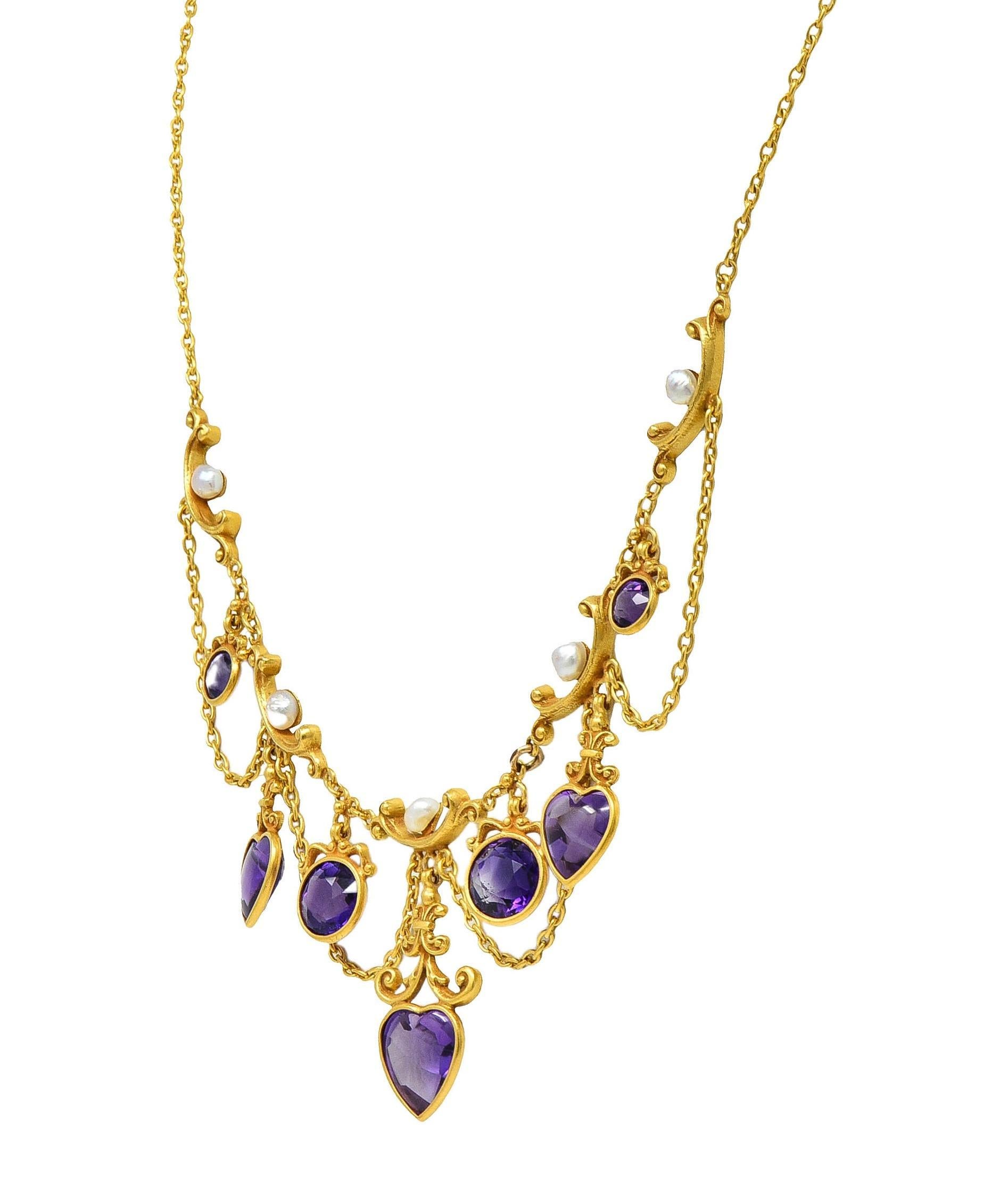 Designed as a cable link chain with swagged central stations featuring articulating amethyst drops
Heart and round cut and graduating in size from 5.0 to 8.5 mm - transparent medium purple
Set in scroll motif bezels matched to scroll motif links