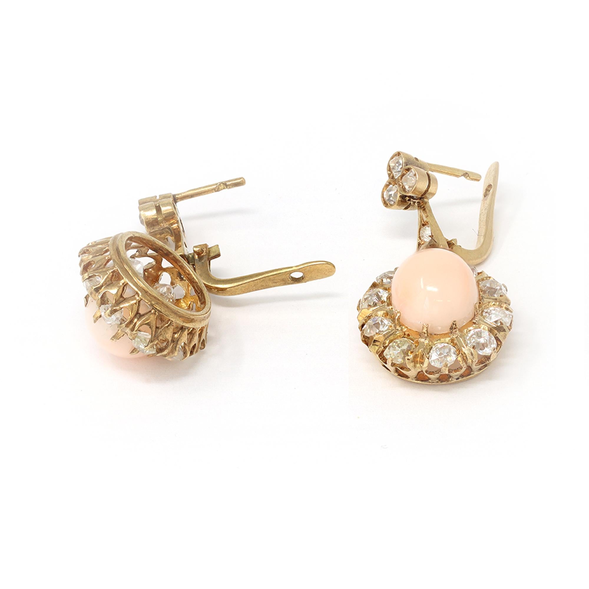 A lovely Victorian era dangling earrings circa 1900 featuring an blush pink AngelSkin Cabochon adorned with an halo of old mine cut diamonds and lever back closure. The earrings are set in 14 karat yellow gold showing some sign of natural oxydation