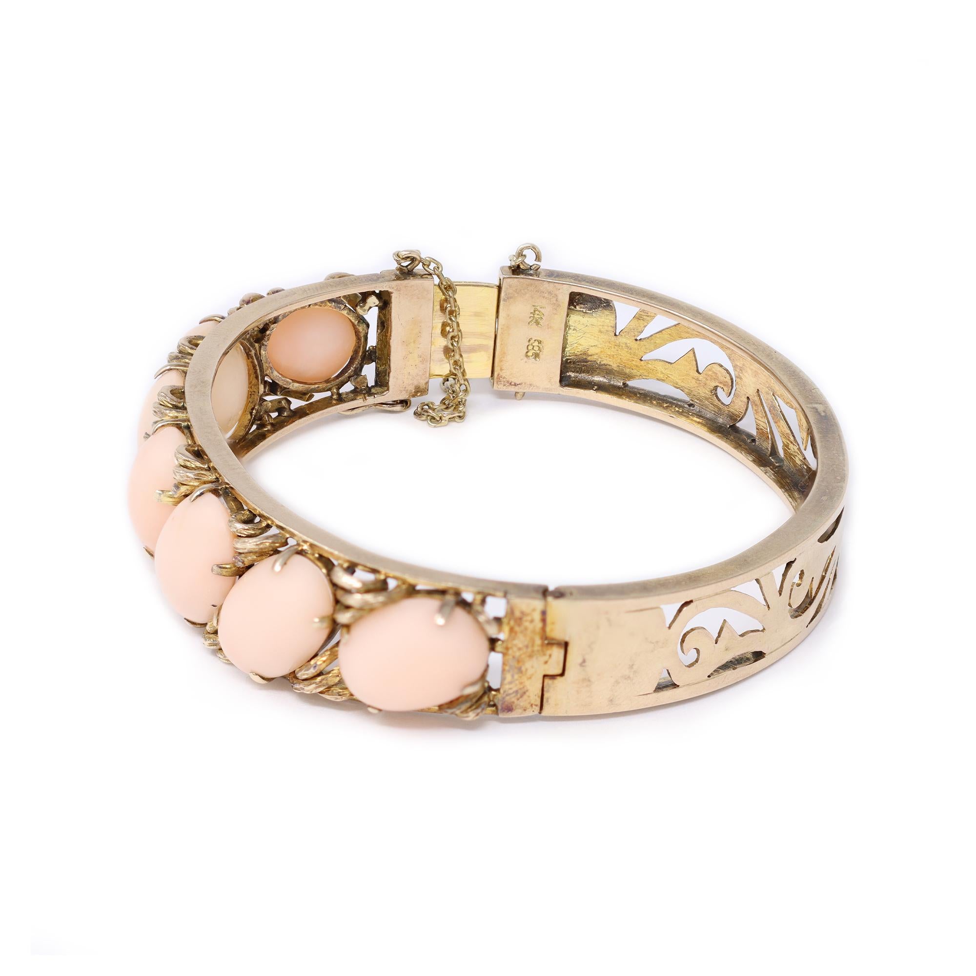 A lovely bangle from the Victorian era circa 1900 featuring matched Angel Skin oval coral cabochons. The hand made bangle bracelet is set in 14 karat rose gold and displays the normal oxydation of an antique piece. The coral cabochons are very even