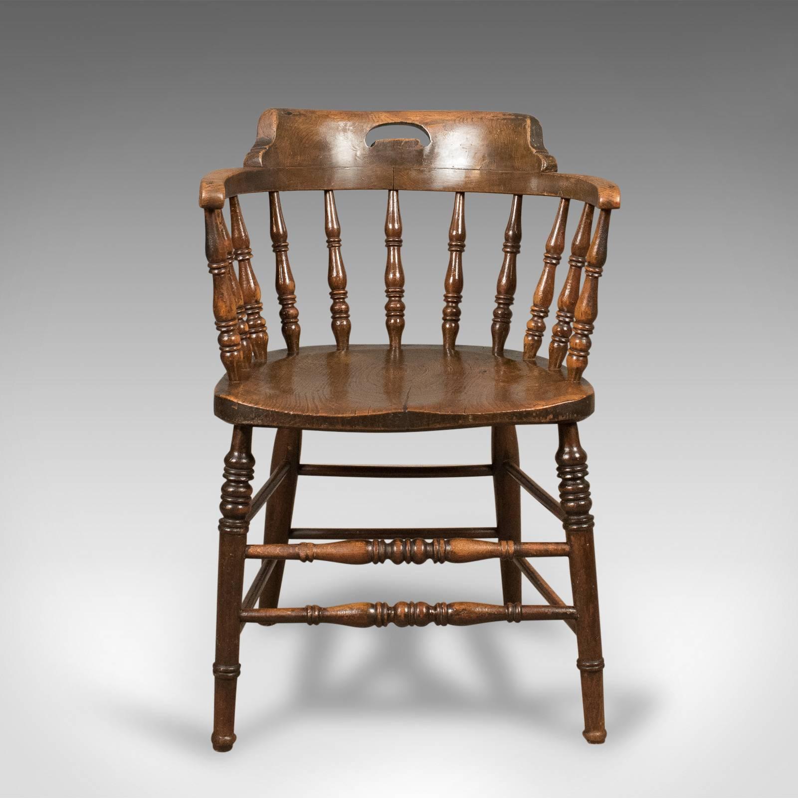 This is a Victorian, antique, low bow-back chair, sometimes referred to as a 'Smokers' or 'Captain's' chair. An English elm Windsor piece from the mid-19th century, circa 1870. 

Attractive deep, rich tones to the elm with a desirable aged