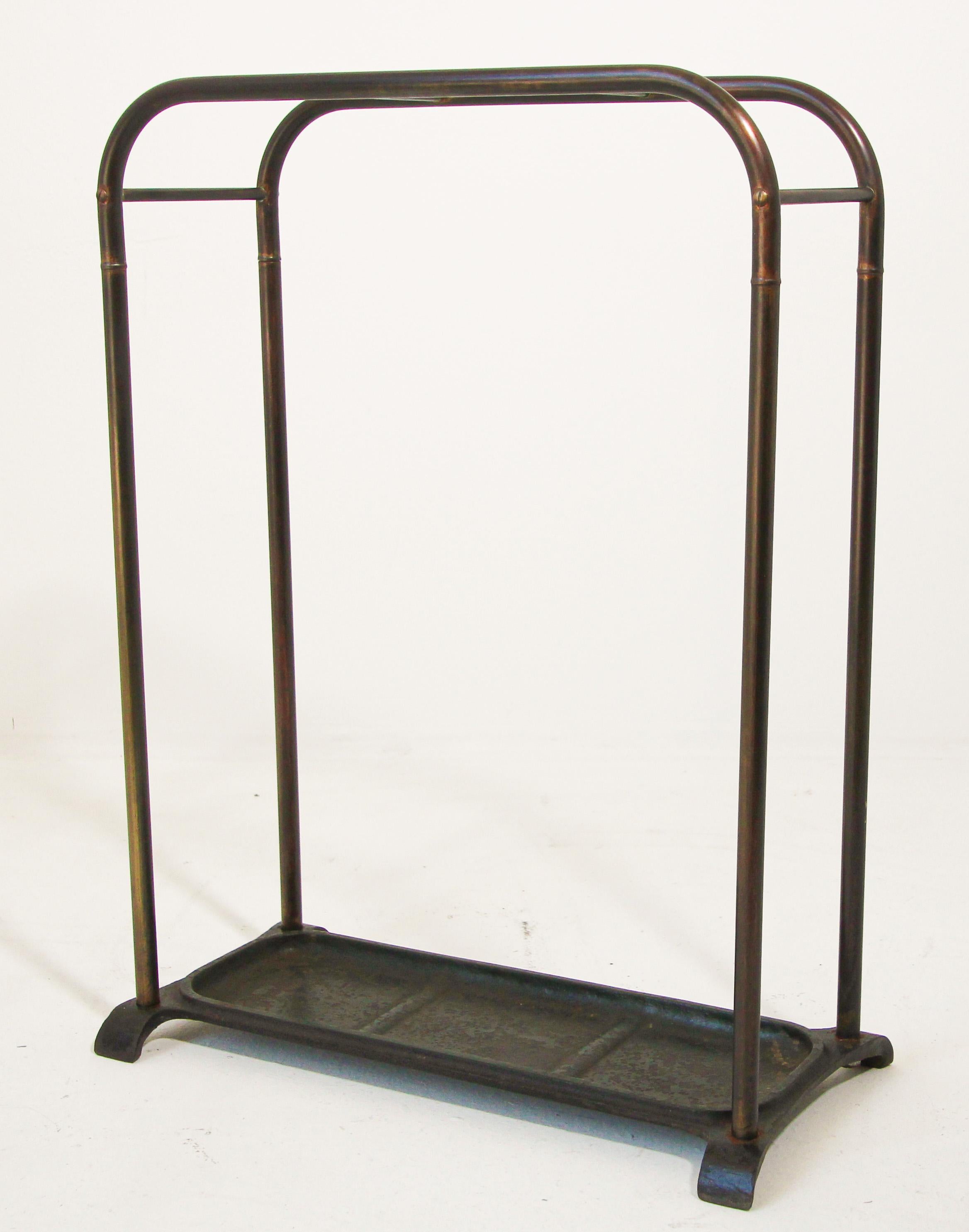 Victorian 19th century brass umbrella stand or stick stand.
Antique brass top divided into three sections to hold either walking sticks or umbrellas.
Umbrella brass valet rack with 3 sections and hunter green iron tray and supported upon a tubular