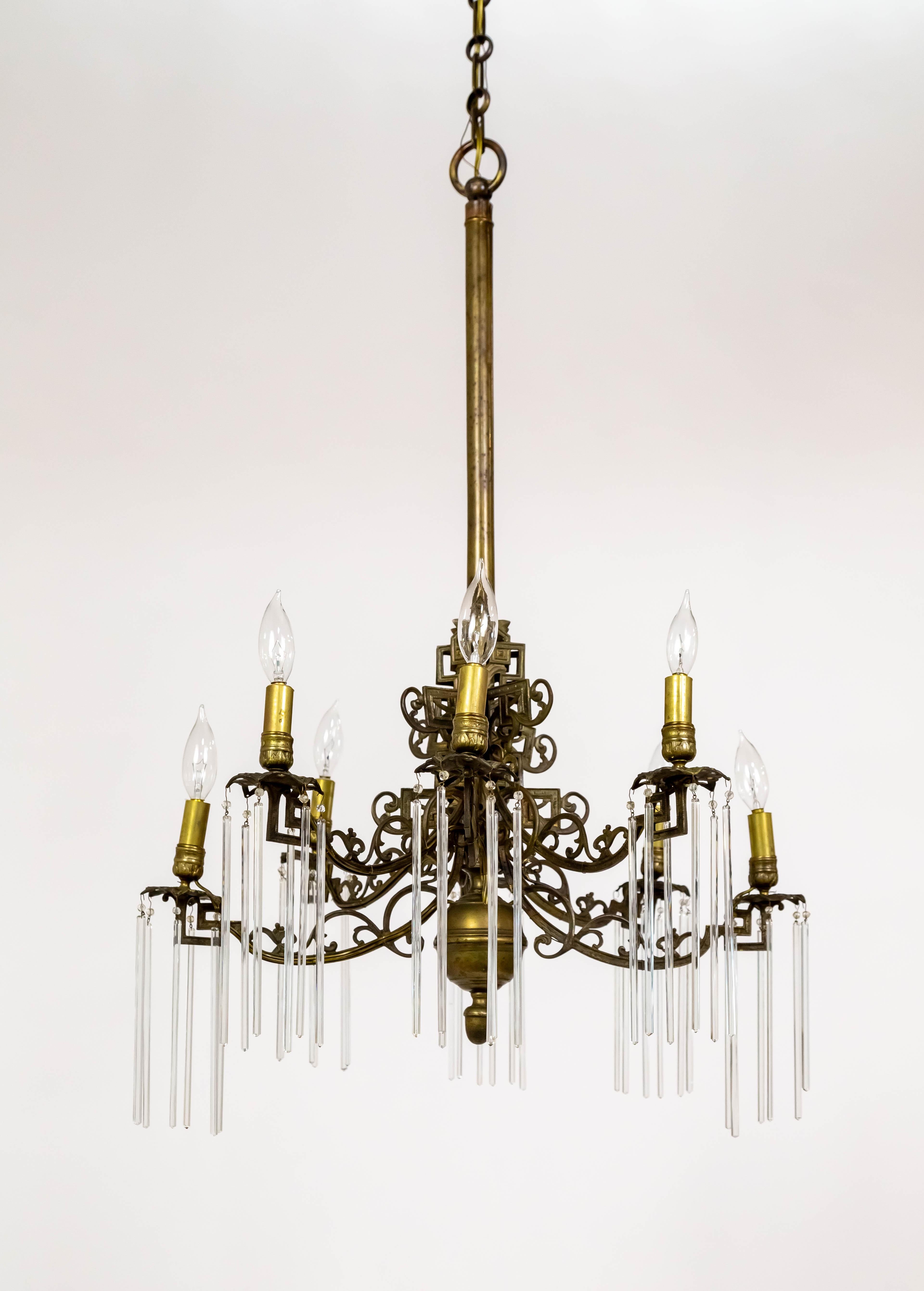 Un lampadario del 1880, precedentemente illuminato da candele, appena elettrificato. Una struttura completamente in ottone con una ricca patina e una fusione in ottone ornata con dettagli arricciati rifiniti con spirali geometriche cinesi. Ha 8