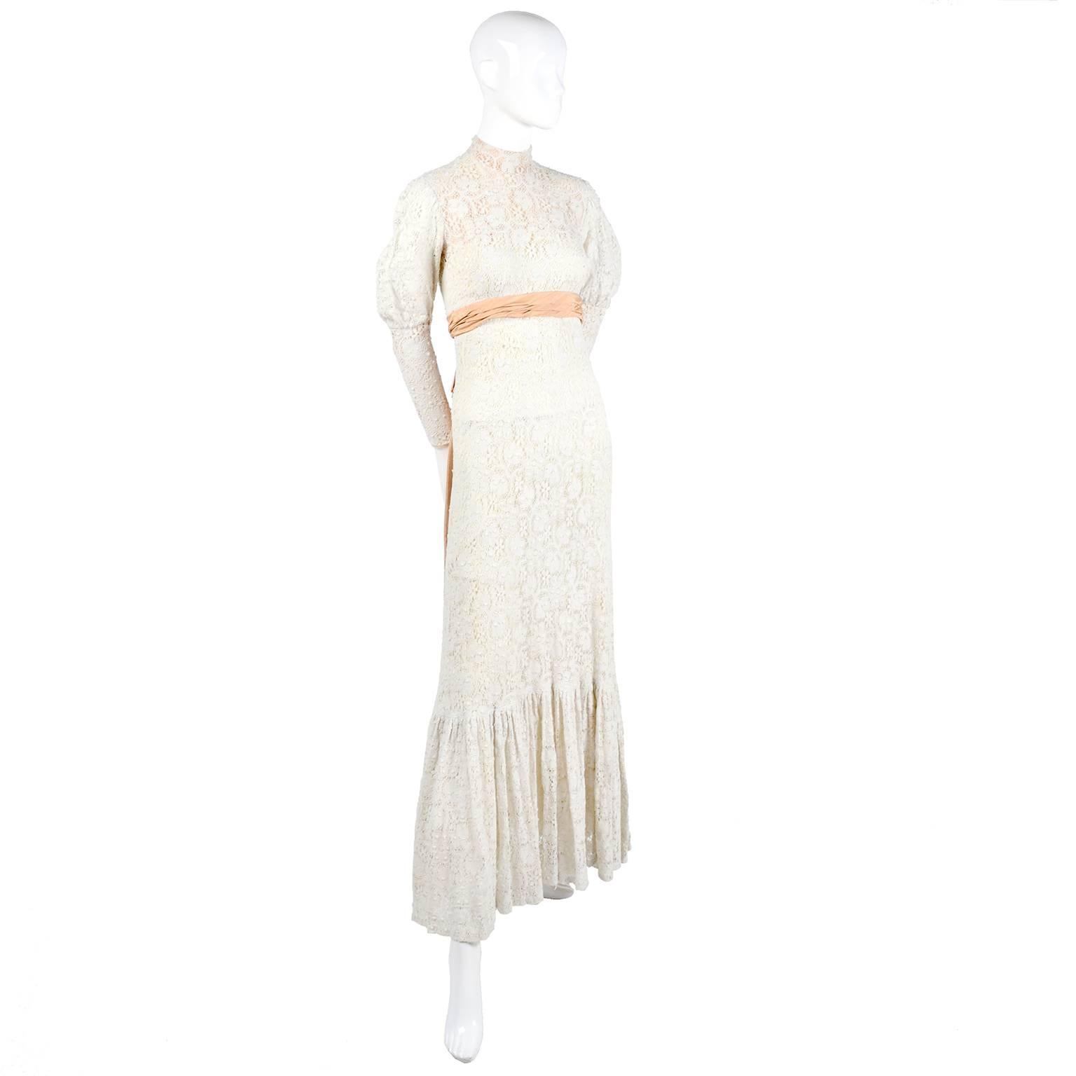 This beautiful Victorian vintage lace dress is simply exquisite with its beautiful ruffled hemline, high collared neckline, and peach moire satin bow in the back. This fabulous vintage ivory Lace dress could be worn as a wedding gown. The dress has