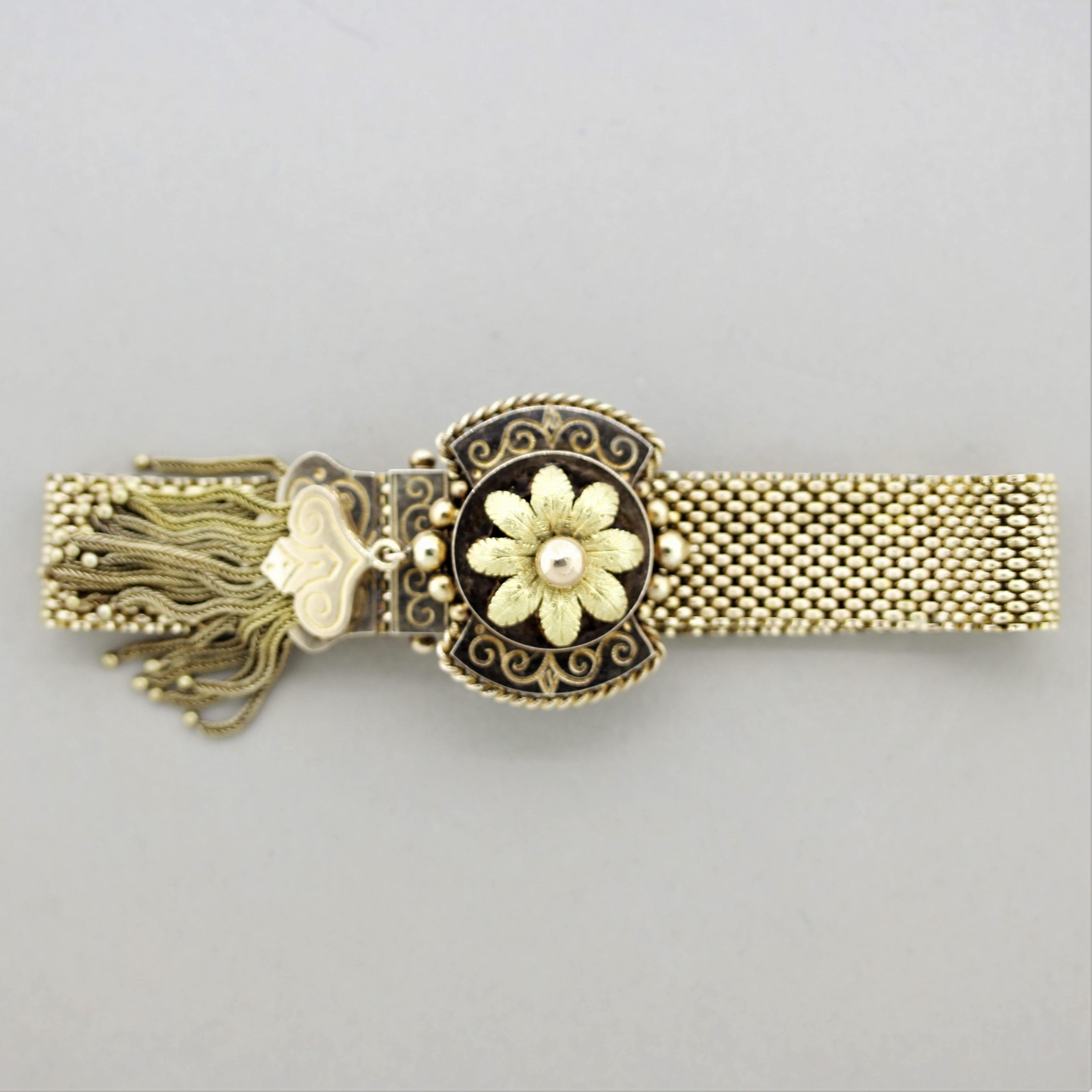 A classic slide bracelet from the Victorian era, circa 1890’s. It has a hand carved and textured floral motif in its center as well as braided gold tassels on its ends. The bracelet slides open and closed to lengthen or shorten with ease. Fits