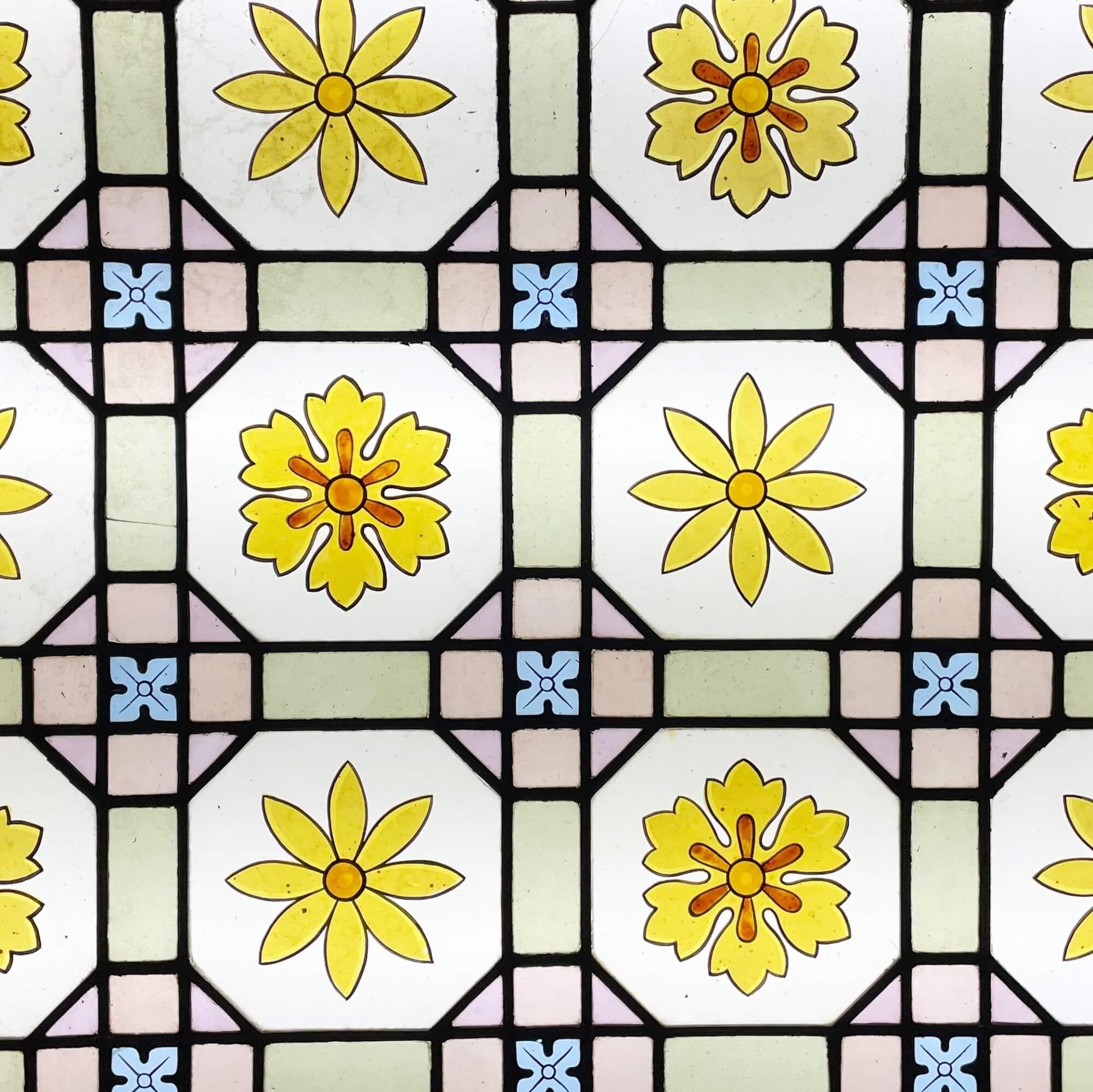 Vitrail antique à motifs floraux de la fin de l'époque victorienne, datant d'environ 1890. Ce vitrail de la fin du XIXe siècle est tout simplement magnifique. Il présente un ensemble de fleurs vibrantes ressemblant à des marguerites, accompagnées de