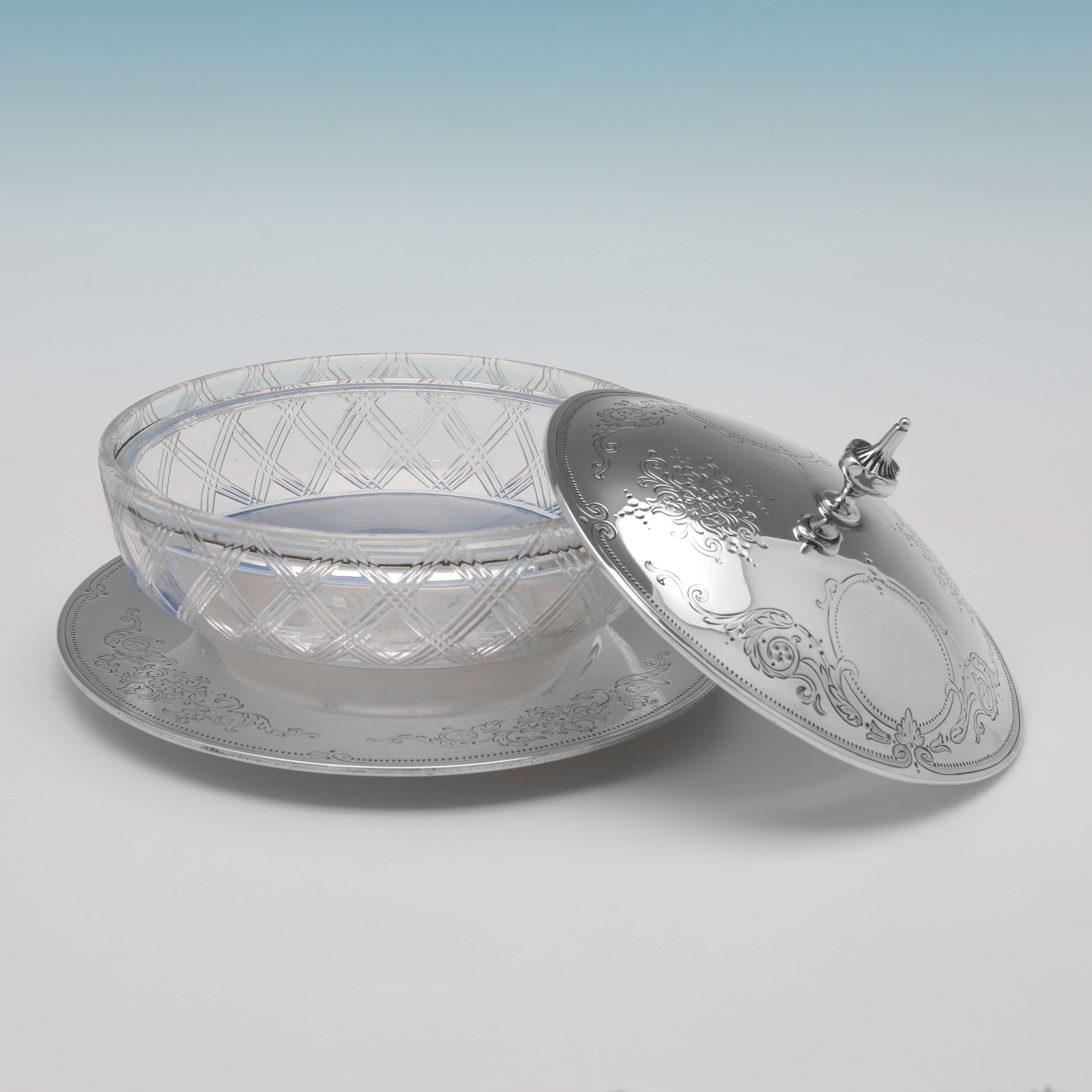 Hallmarked in London in 1866 by George Angell, this very attractive, Victorian, antique sterling silver butter dish, features an engraved silver lid and base, with a cross hatched cut glass body. The butter dish measures 4