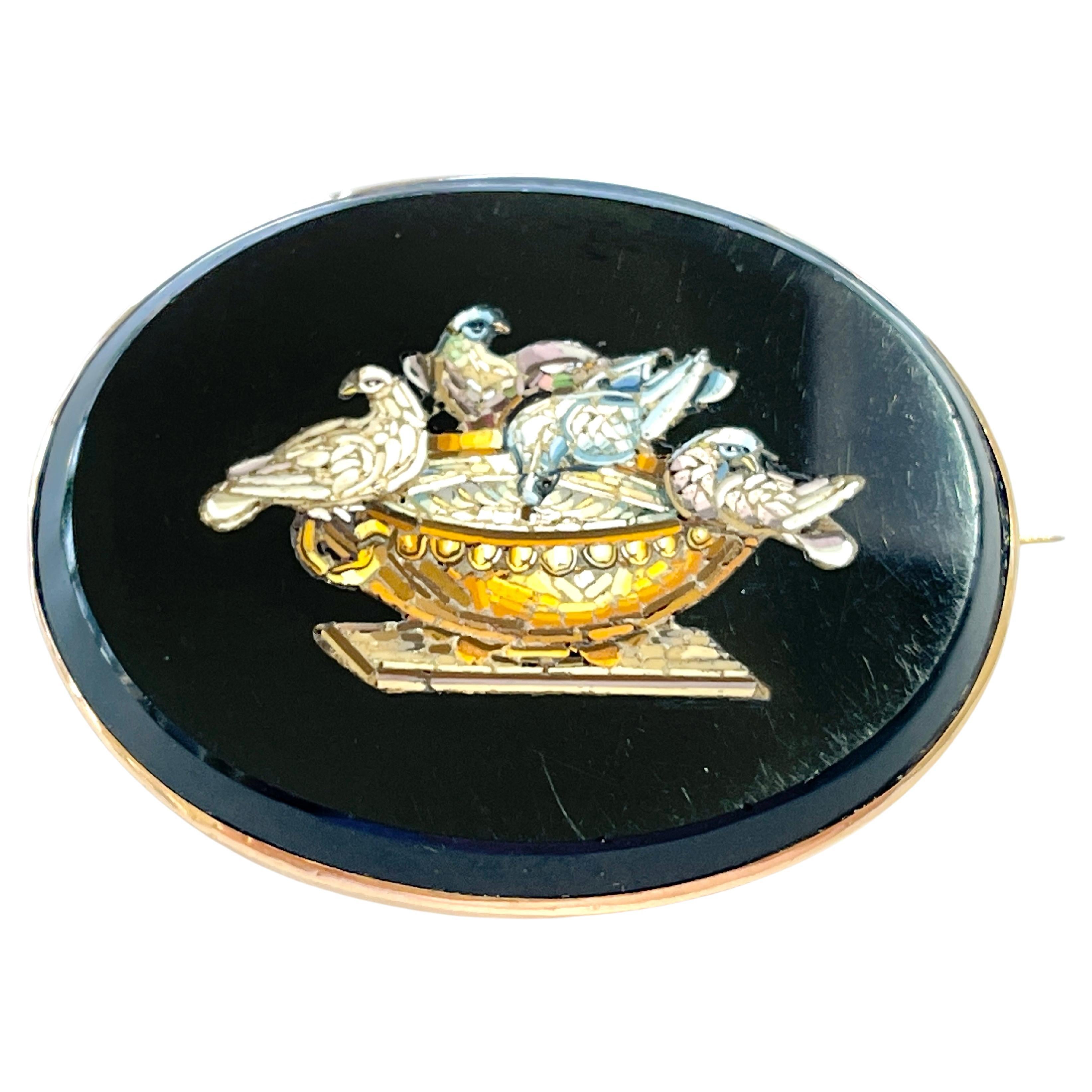 This stunning brooch embodies the Victorian Era of the 'Grand Tour' c1880s.
It features the ‘Doves of Pliny’ created by micro pieces of coloured glass inlayed into black glass.  The setting tests 15ct Rose Gold but is not stamped.  The piece is