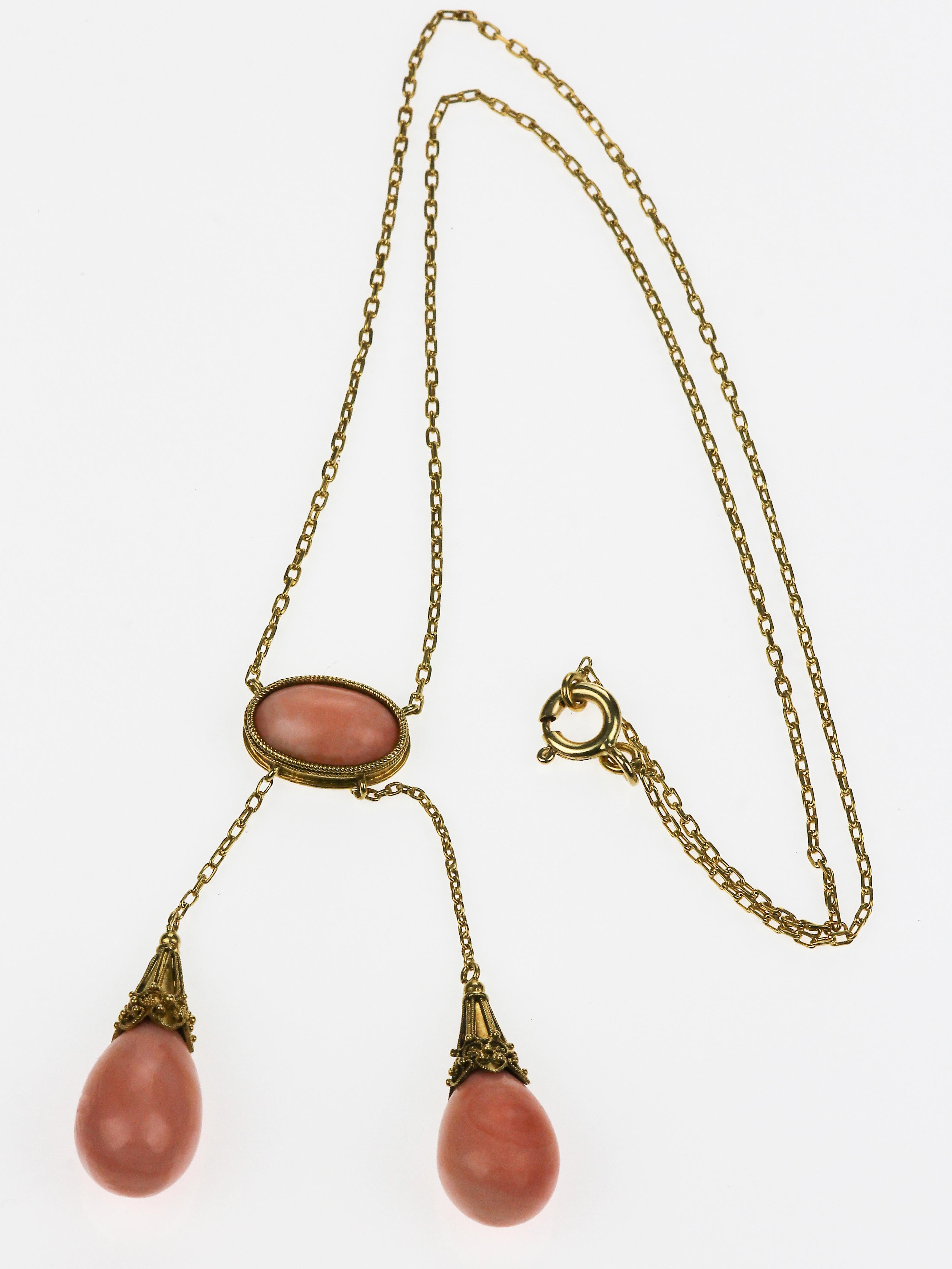 Gorgeous, this piece is a unique victorian antique necklace containing several pastel pink corals in different shades which aluminate the room. The corals are in various shapes, two are teardrops resembling bulbs encased in a beautiful gold accent