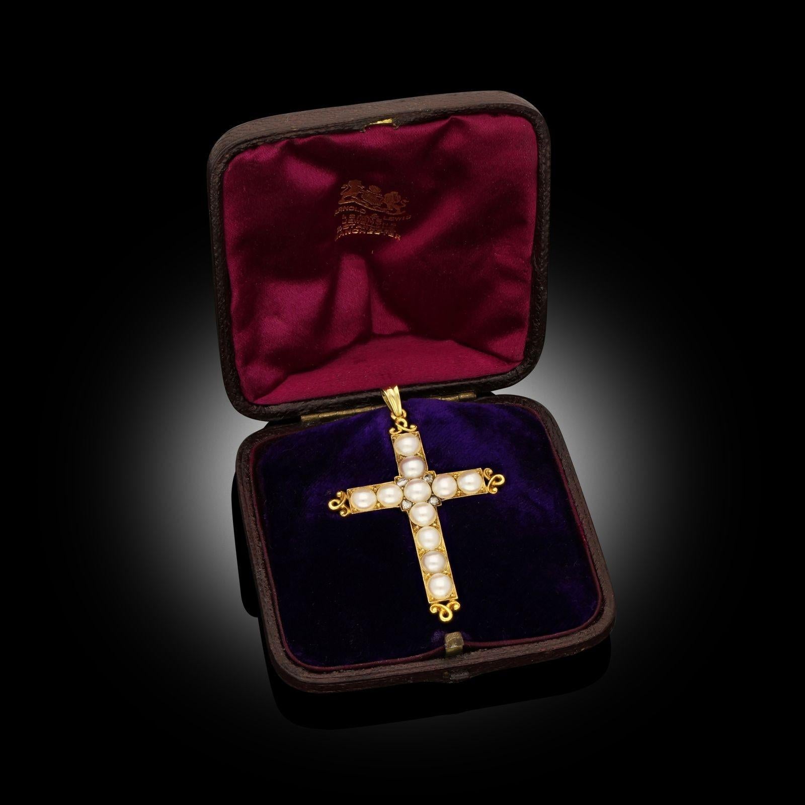 A Victorian pearl and diamond cross pendant circa 1890. This Latin style cross is set with natural saltwater half pearls with four small old cut diamonds embellishing the centre. The cross terminations each have an ornate scroll design all set in