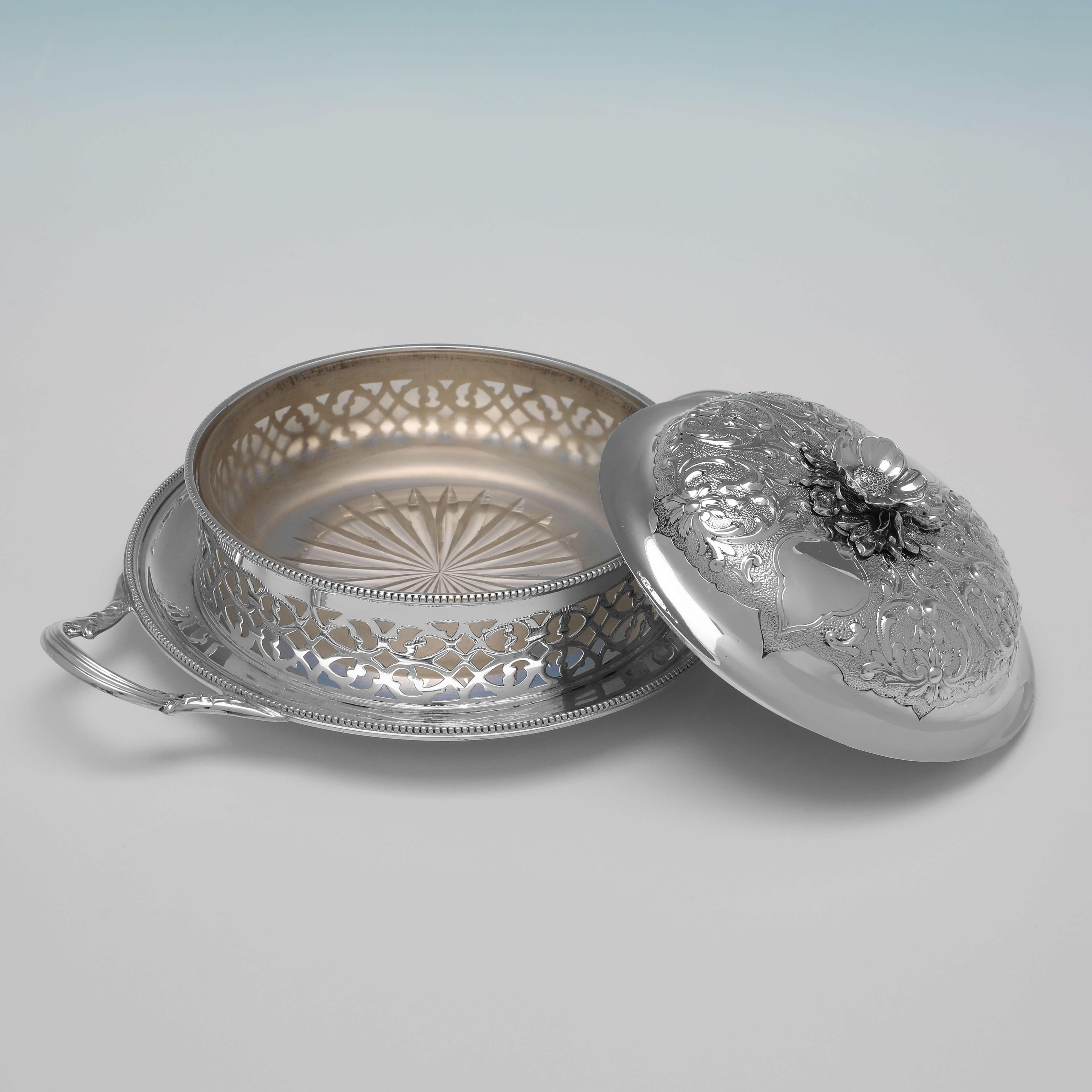 Hallmarked in Sheffield in 1865 by Henry Wilkinson & Co., this attractive, Victorian, Antique Sterling Silver Butter Dish, features pierced sides, a glass liner, and an ornate lid. 

The butter dish measures 3